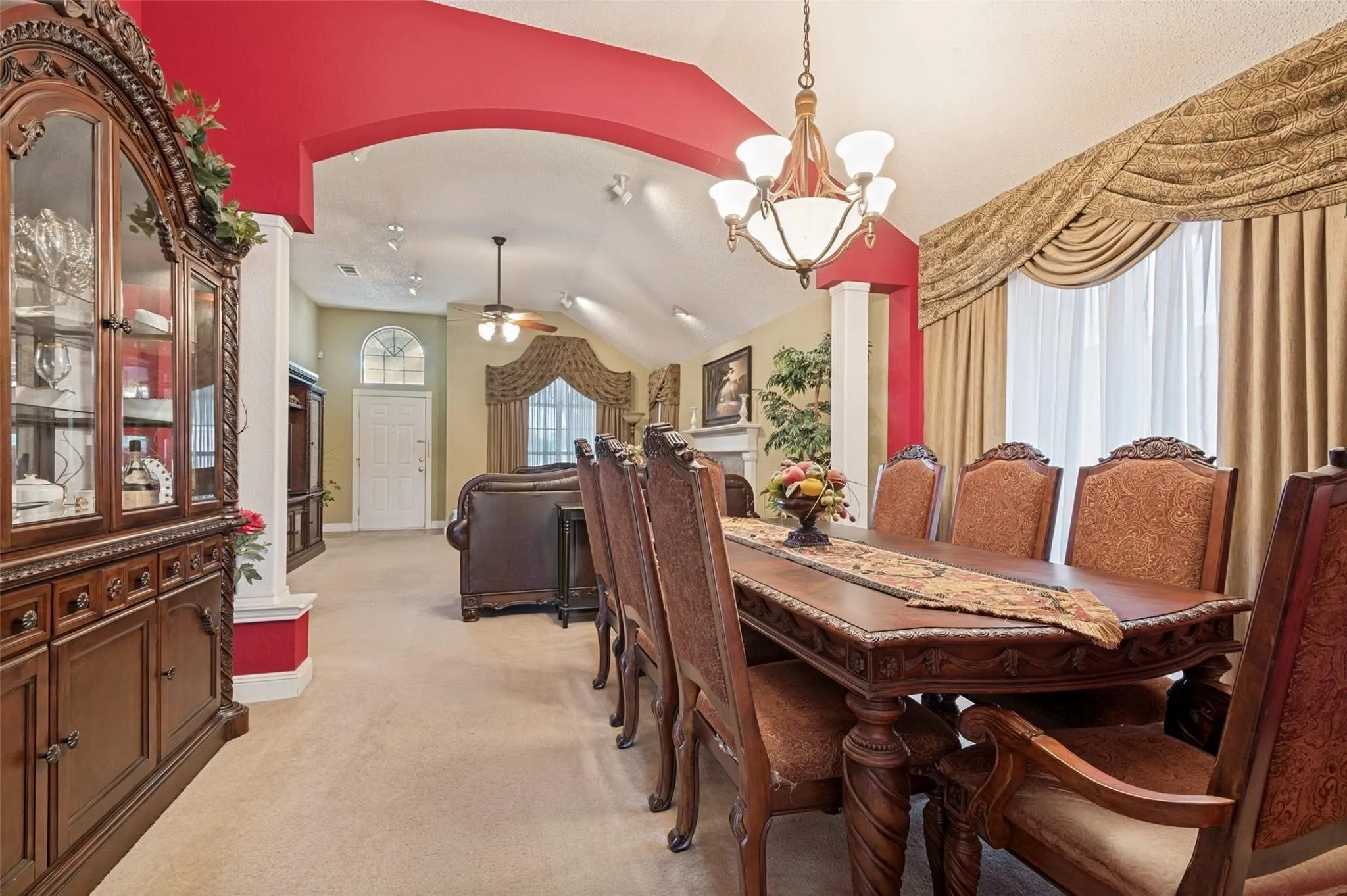 Vaulted ceilings, archway accent, chandelier lighting, recessed lighting, and decorative window treatments