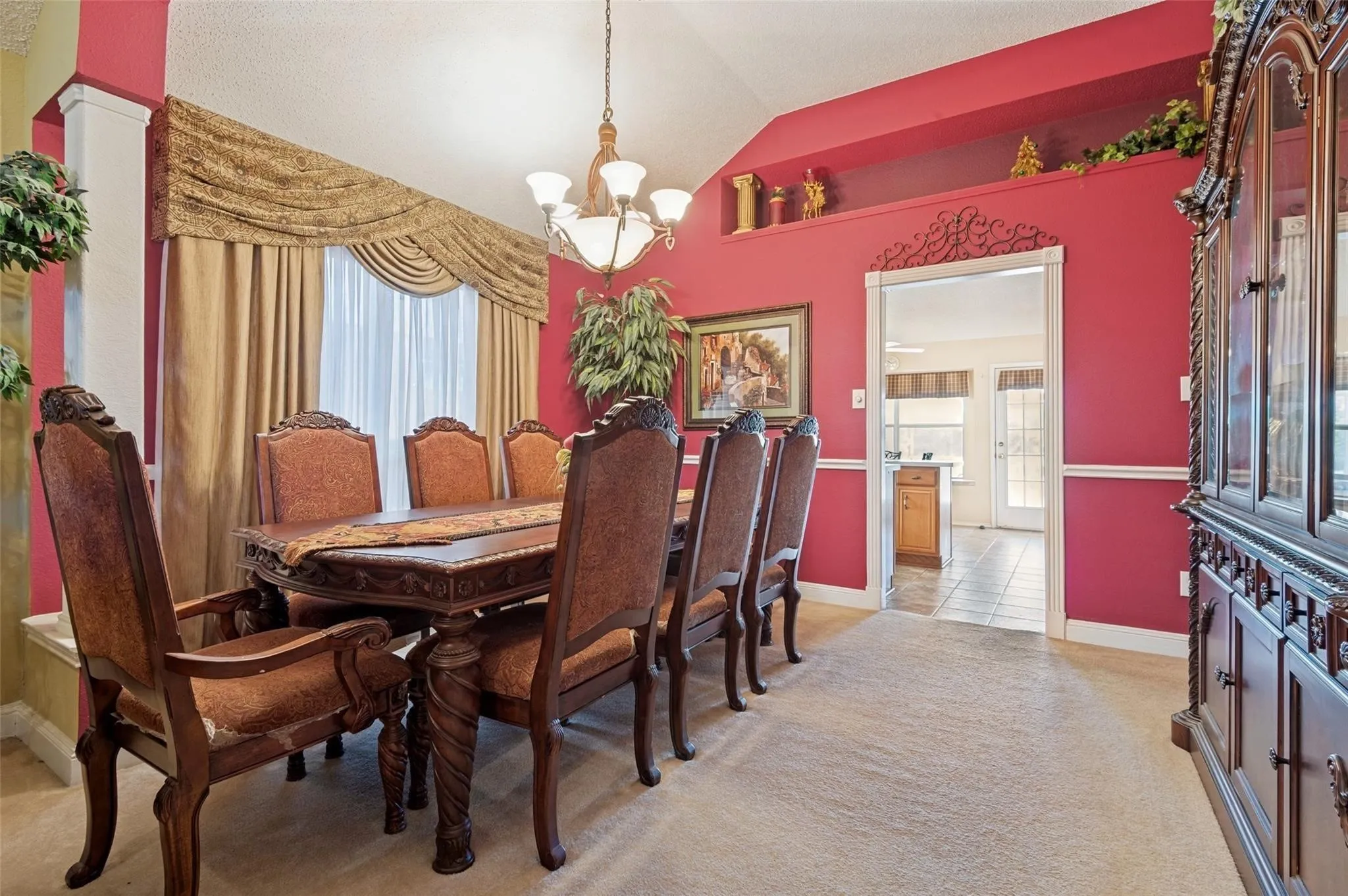Vaulted ceiling with chandelier, architectural column, window with valance, decorative wall shelf, and wall molding