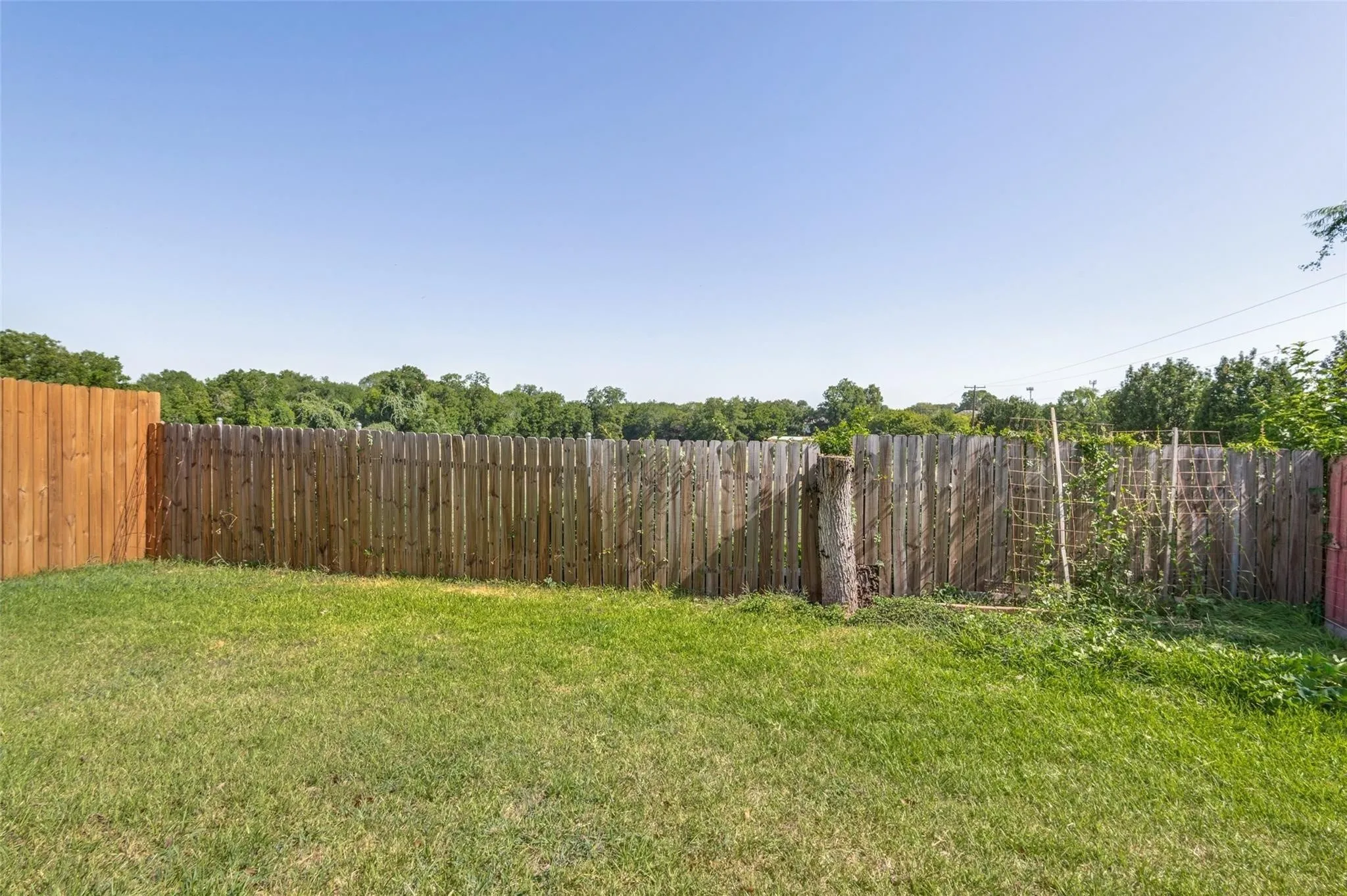 Expansive yard space featuring a mix of wood privacy fencing