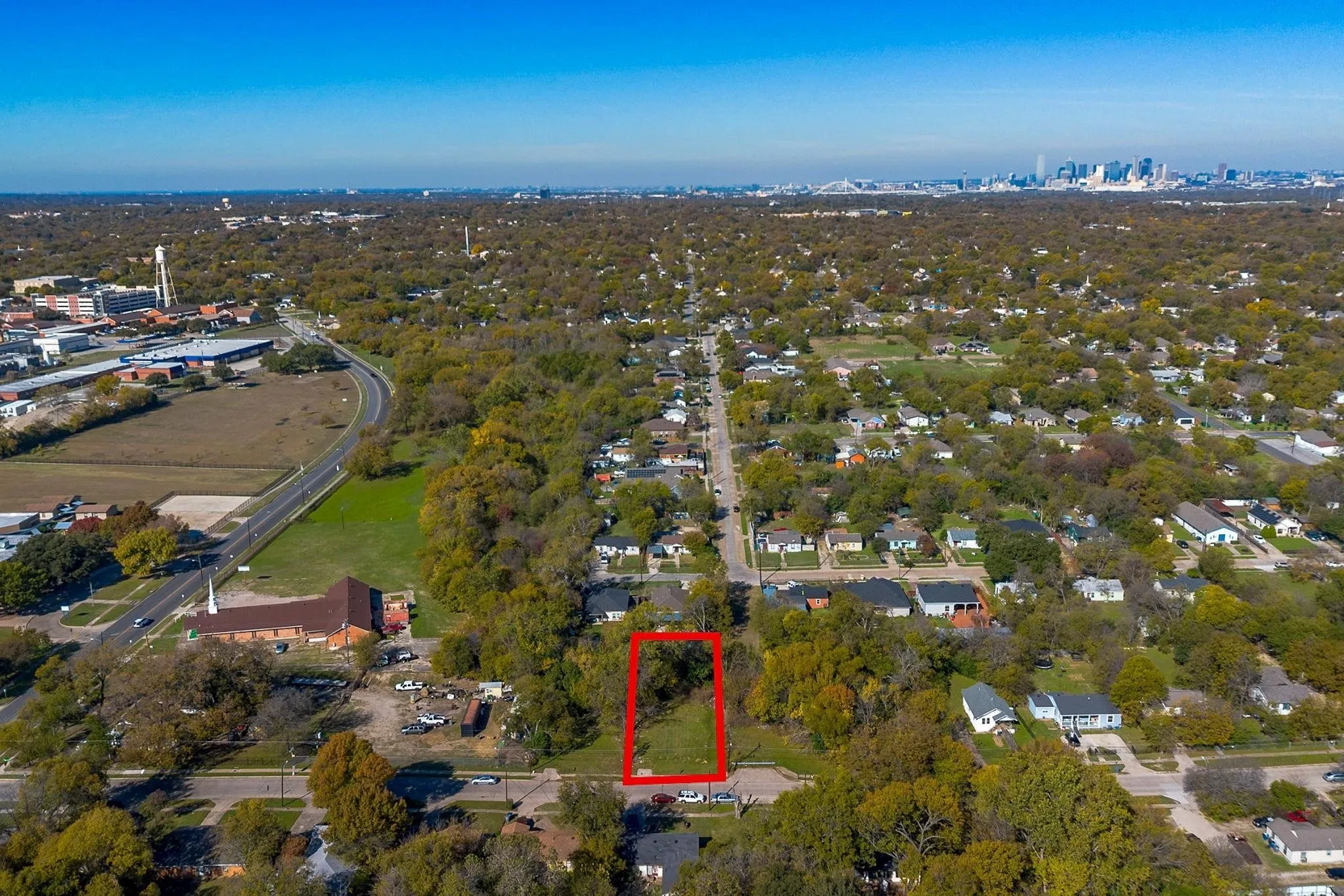 Vacant lot with surrounding mature trees, offering a clear development opportunity
