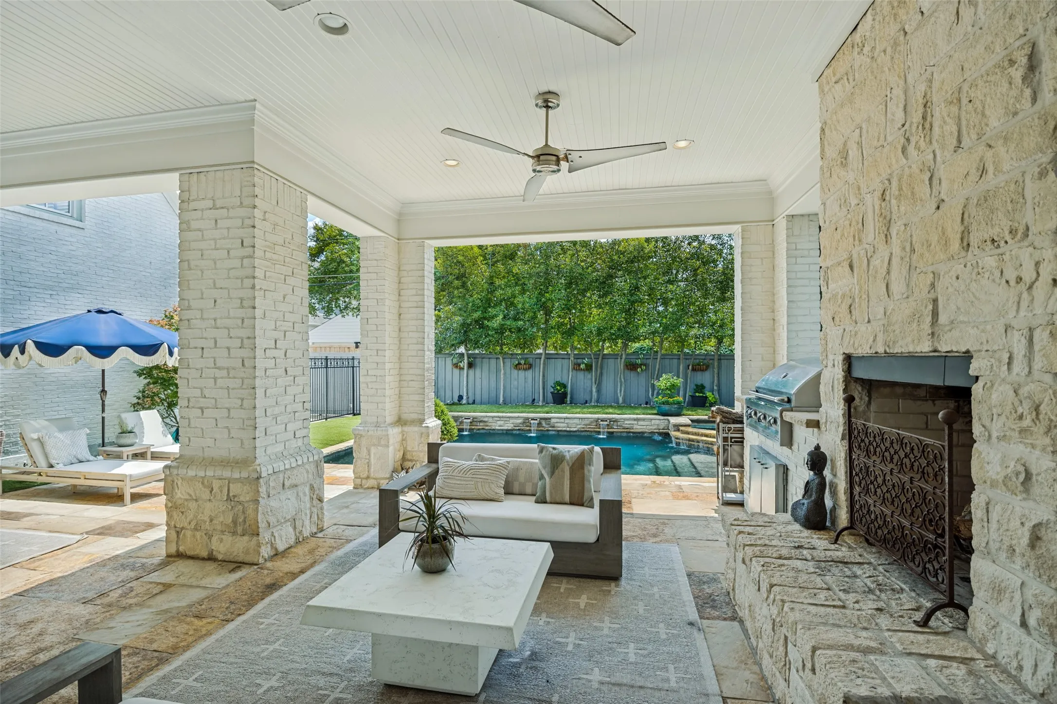 Covered patio with outdoor fireplace and kitchen.