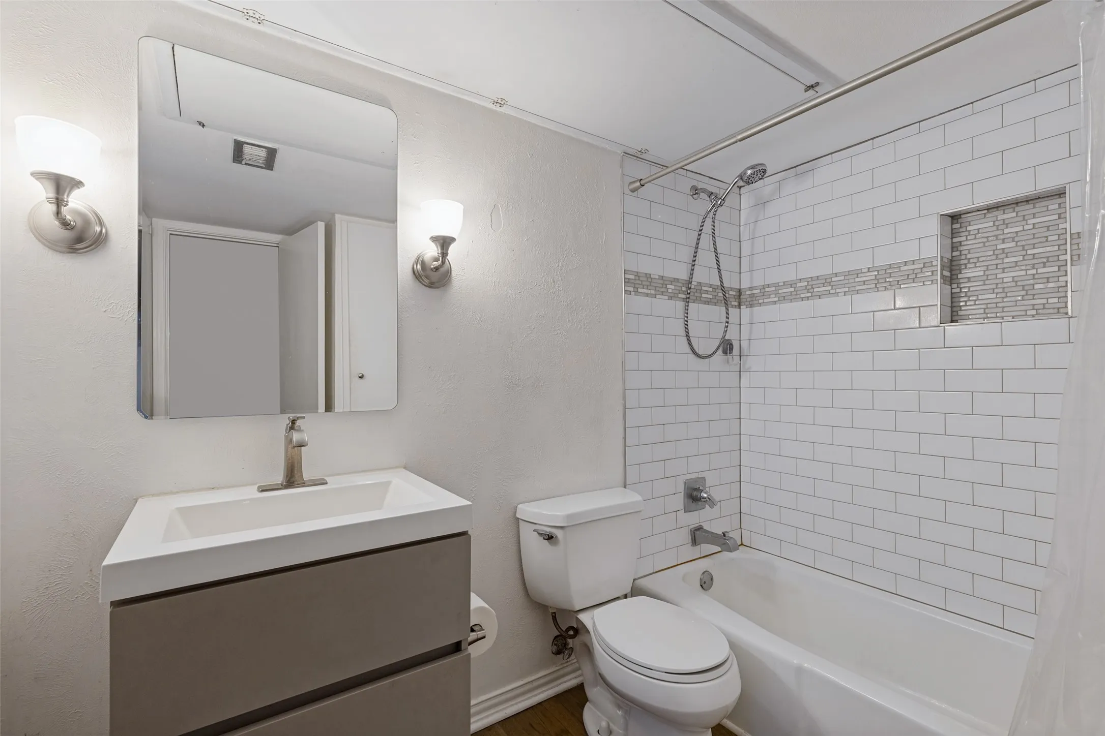 Built-in vanity with a rectangular basin, brushed nickel faucet, and wall-mounted mirror