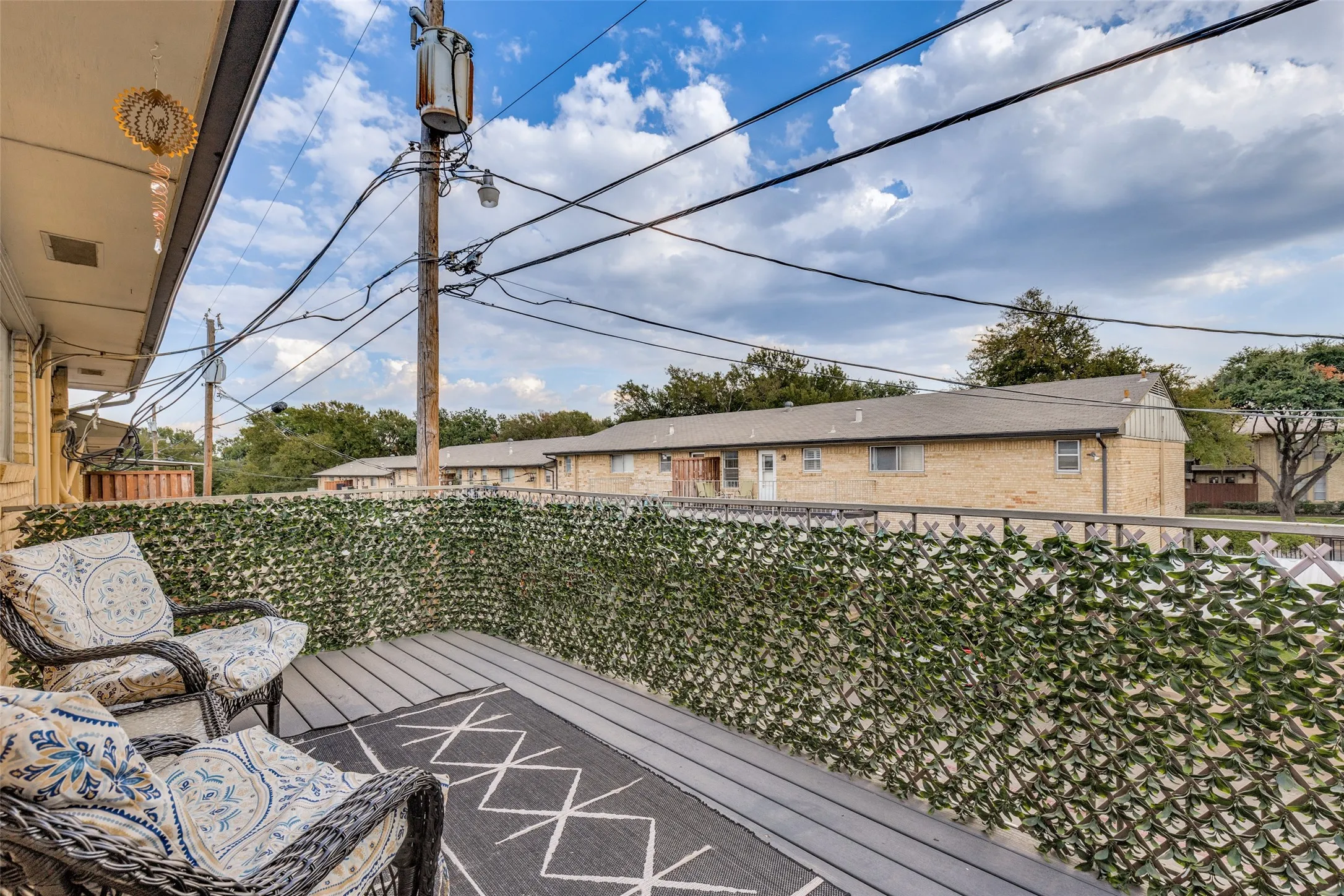 Private balcony featuring a decorative privacy screen and a wood-finish floor