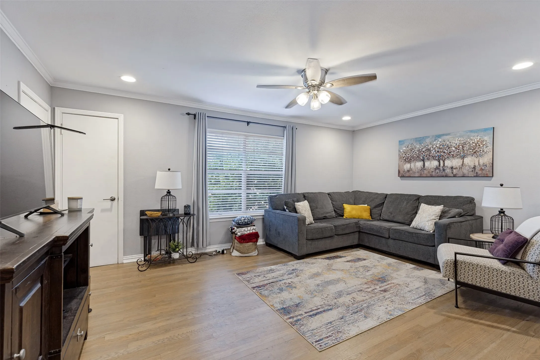 Recessed lighting, crown molding, wood-finish flooring, ceiling fan, and window with blinds