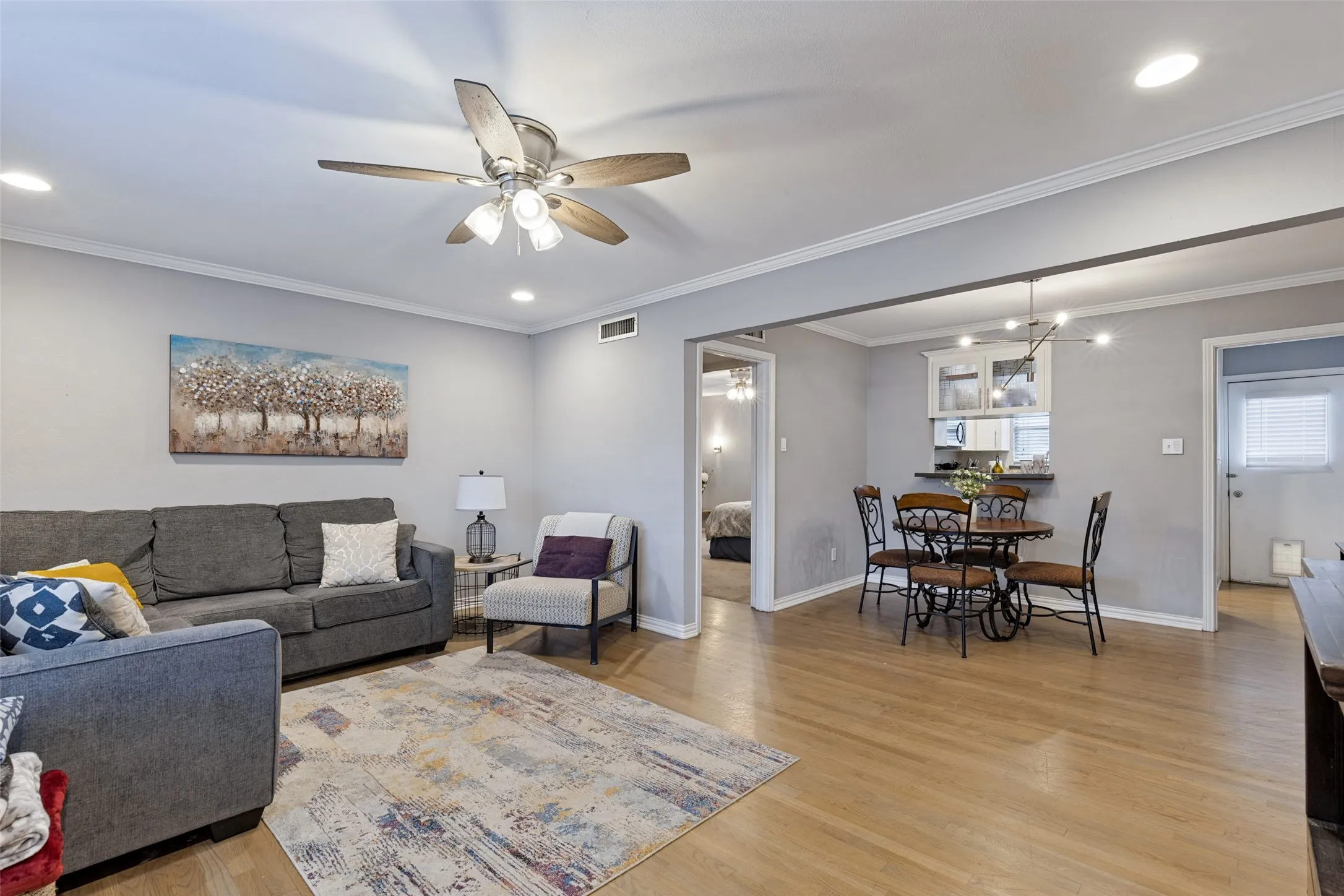 Recessed lighting, crown molding, wood-finish flooring, ceiling fan, and a built-in breakfast bar