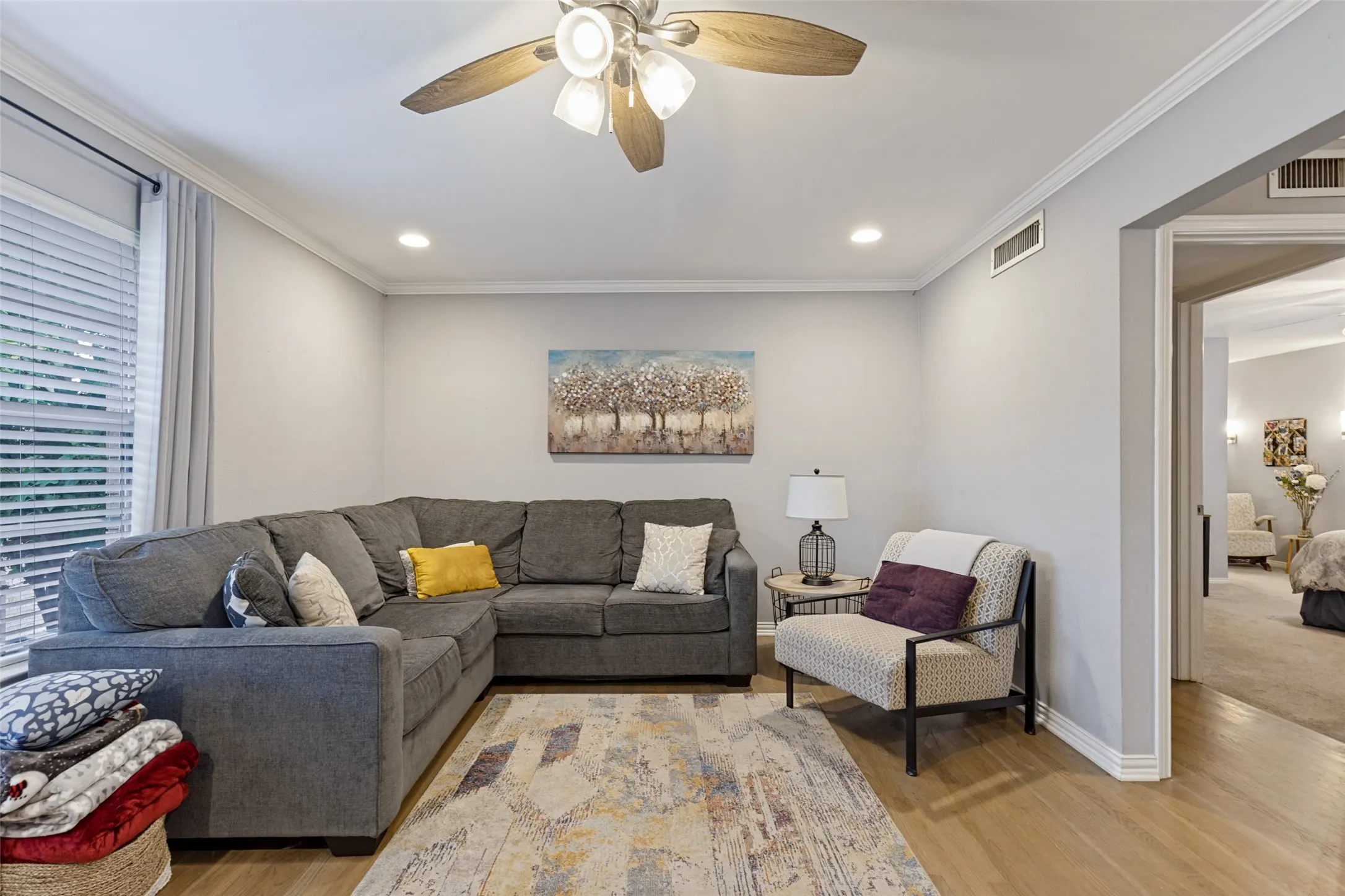 Recessed lighting, wood-finish flooring, ceiling fan with integrated lighting, window with blinds, cased opening