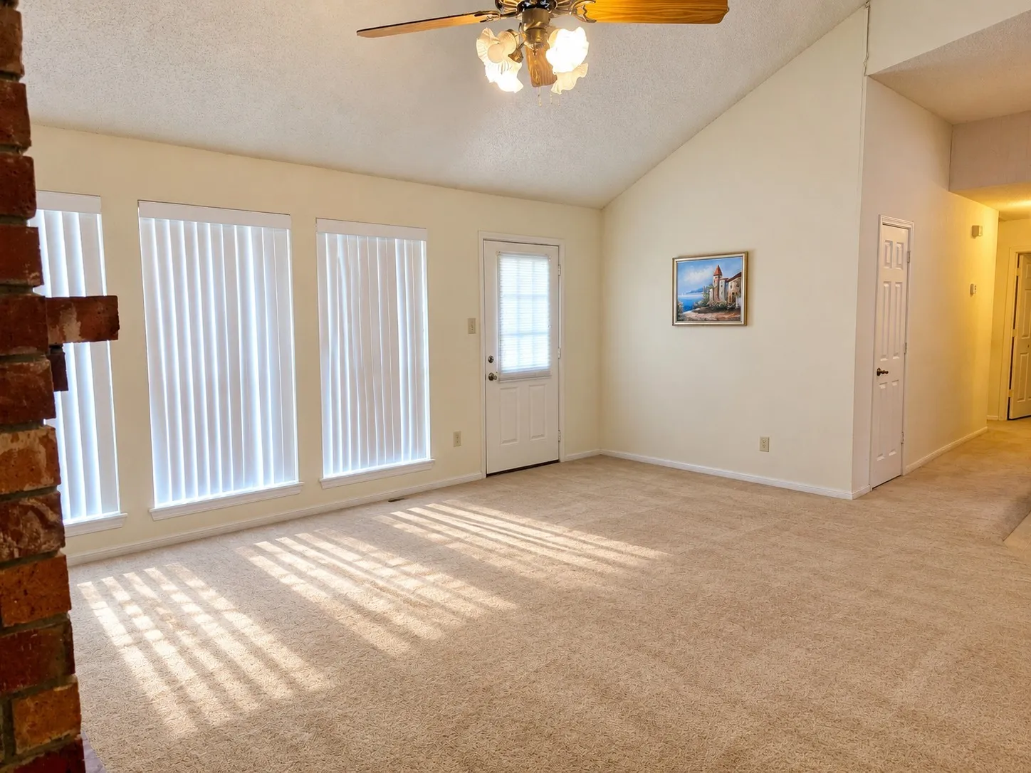 Vaulted ceiling with a ceiling fan. VIRTUALLY DECLUTTERED USING AI