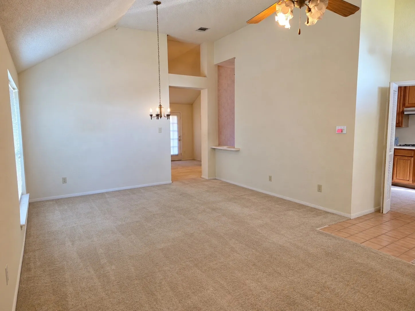 Vaulted ceilings with a brass chandelier and ceiling fan - VIRTUALLY DECLUTTERED USING AI