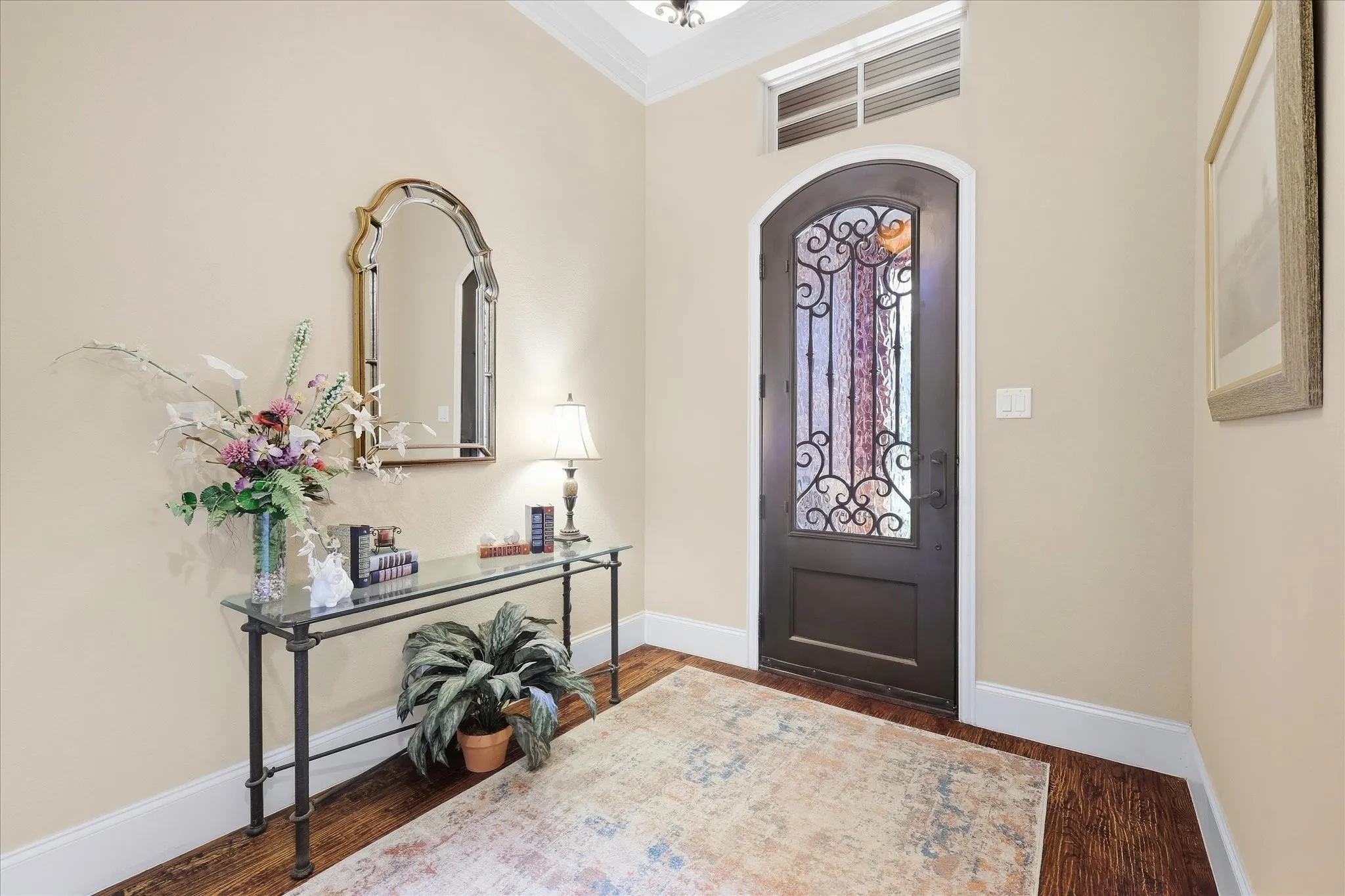 Arched entry door with decorative ironwork and an upper transom window