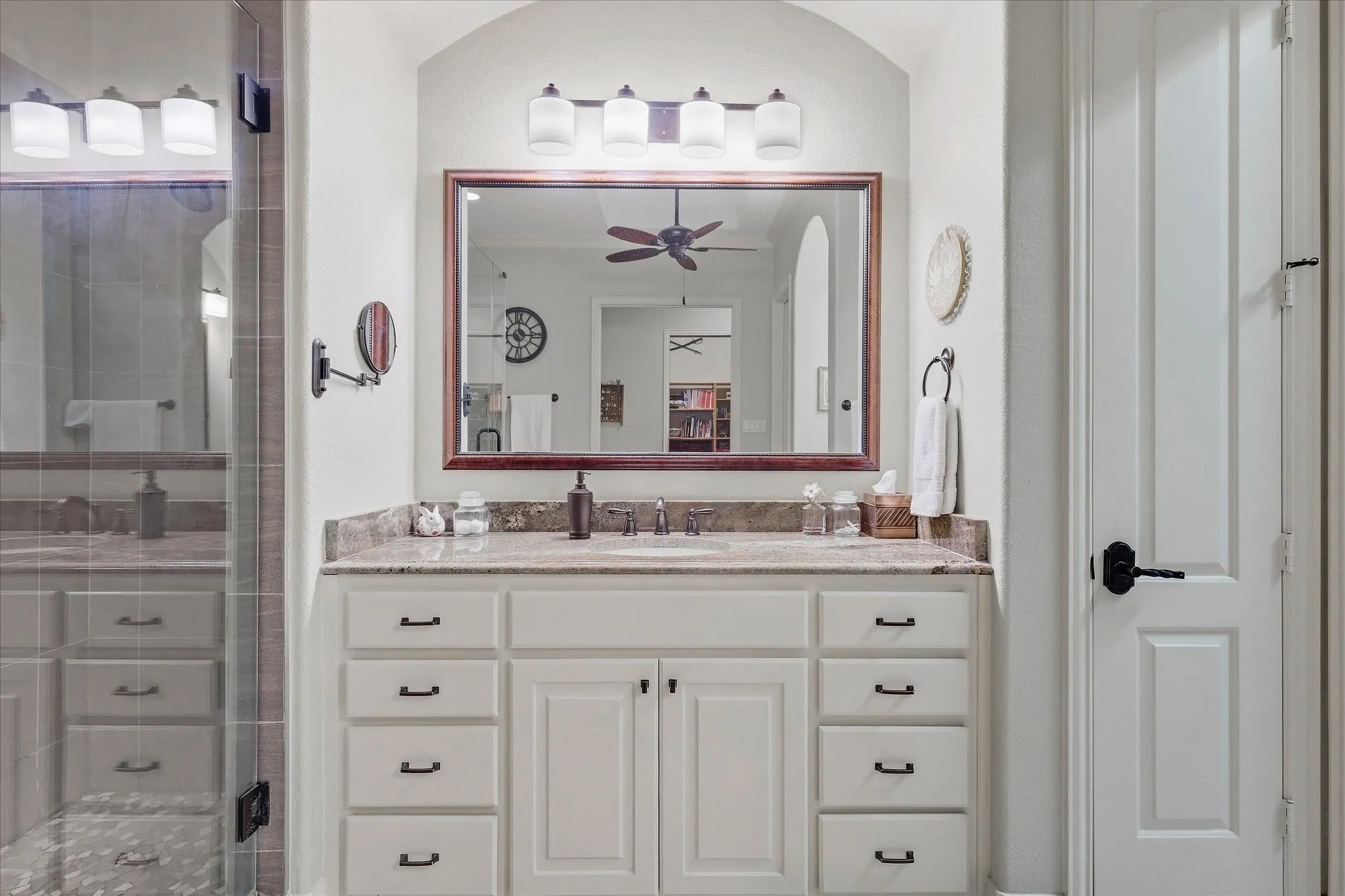 Vanity featuring a stone countertop, undermount sink, and integrated cabinetry with black hardware