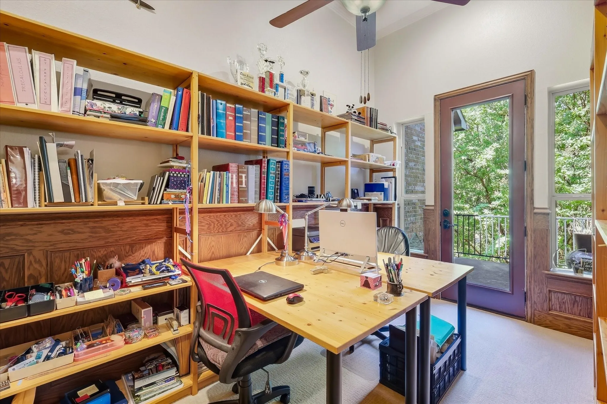 Beautiful wood wainscoting, full-light exterior door, transom window, and ceiling fan.  Desk and shelving do not convey.