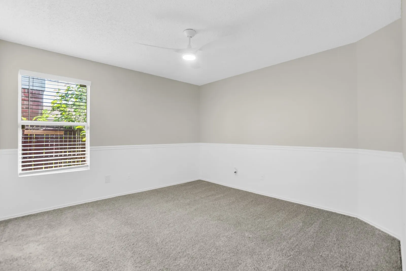 Recessed lighting, ceiling fan, wall paneling, light gray walls, and carpeting
