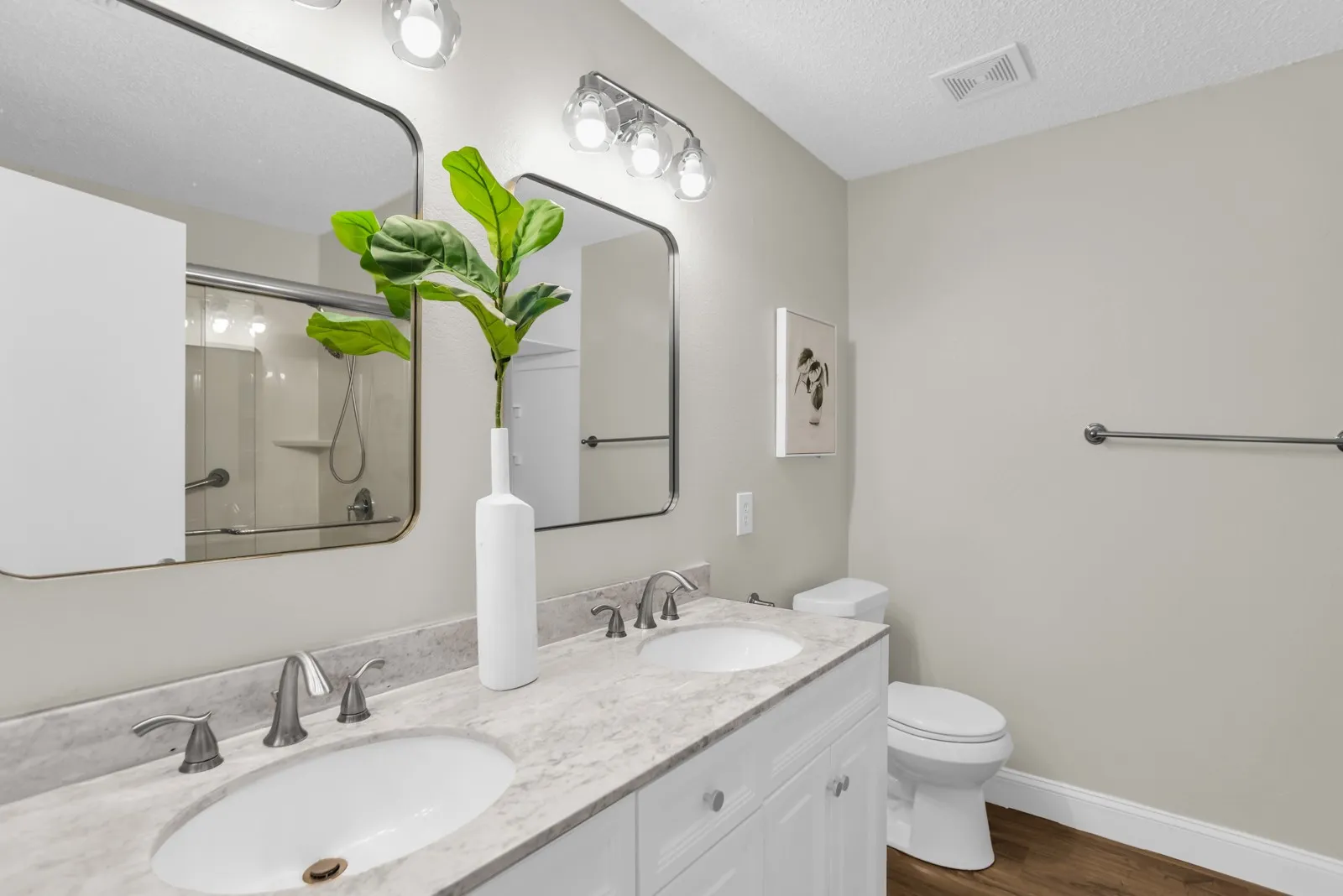 Dual oval undermount sinks with brushed nickel fixtures, set into a light-toned countertop