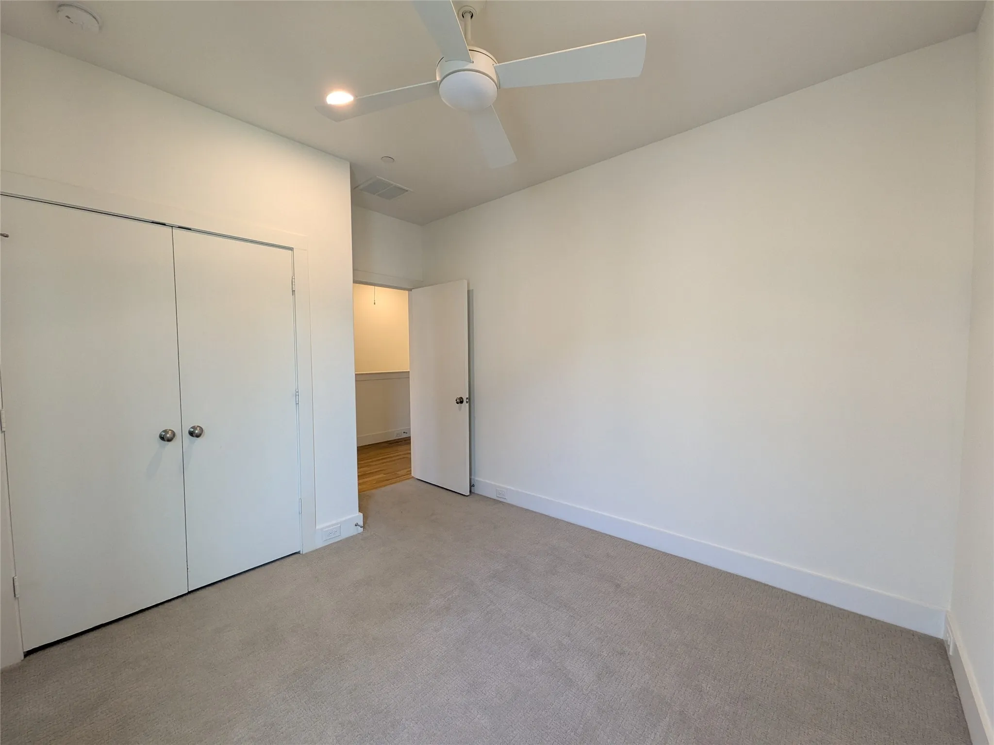 Plush carpeting, recessed lighting, ceiling fan, bi-fold closet doors, and a solid core door
