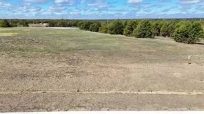 Expansive lot featuring mature perimeter trees and a clear, level building area