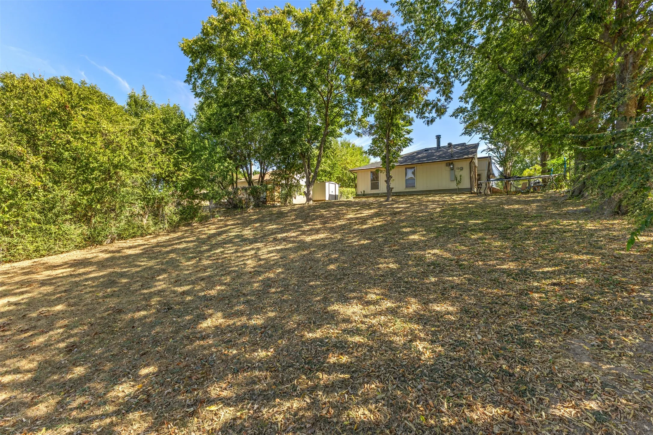 Expansive lot with mature trees, providing natural shade and a secluded setting