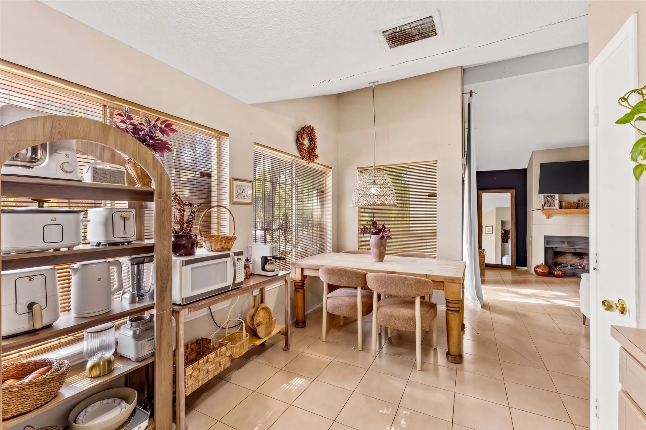 Tiled flooring, vaulted ceilings, and a corner fireplace with a mantel