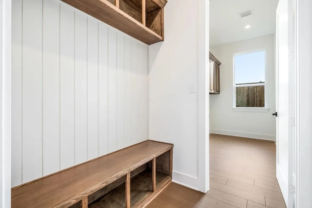 Built-in wood-finish bench with cubby storage and an overhead shelf