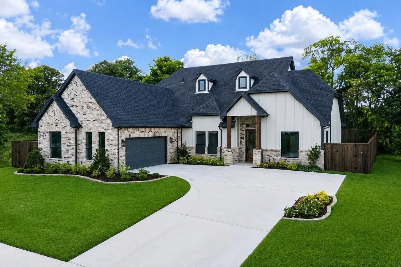 Expansive green lawn with a wood privacy fence and mature trees