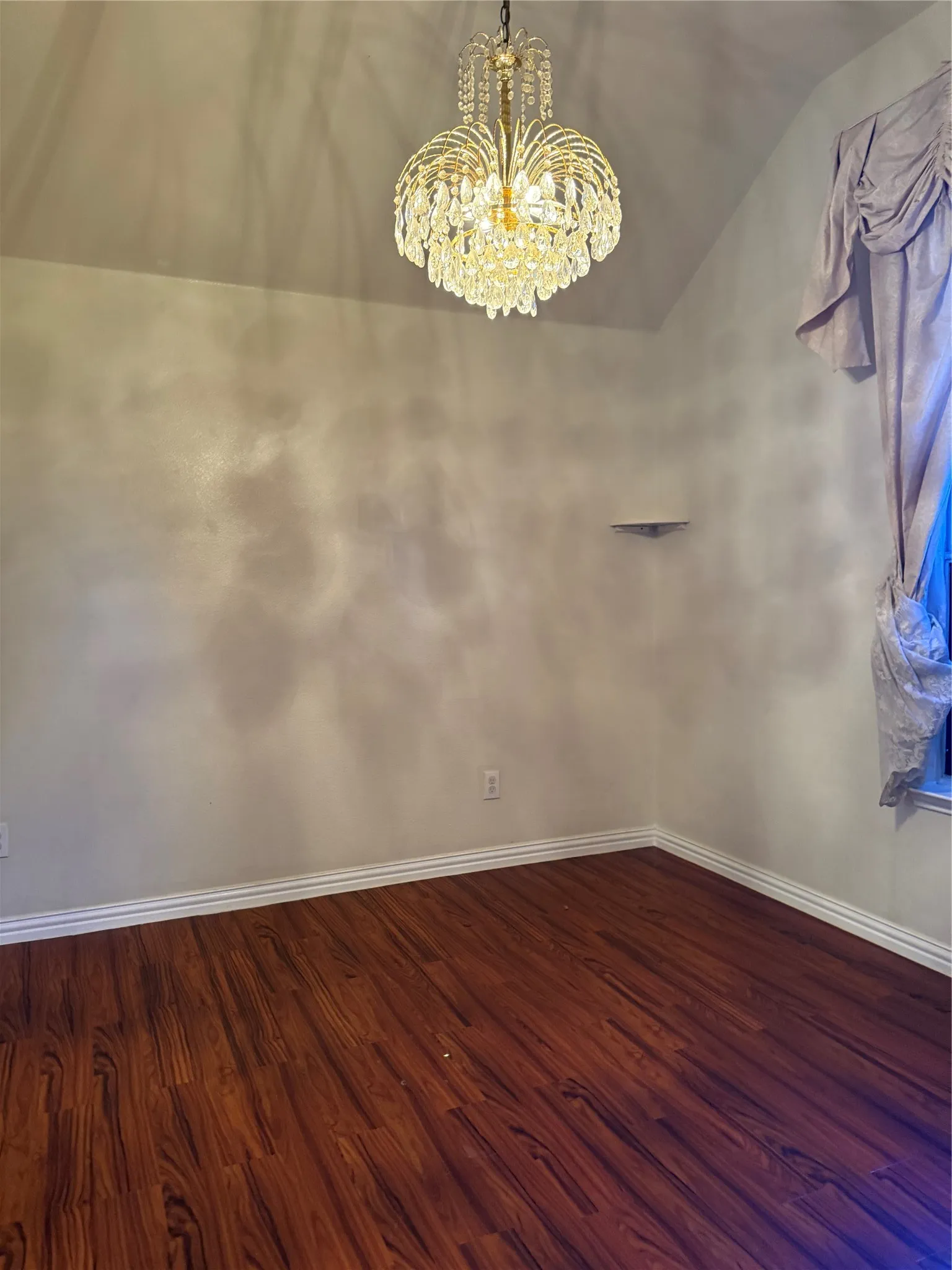 Vaulted ceiling featuring a crystal chandelier