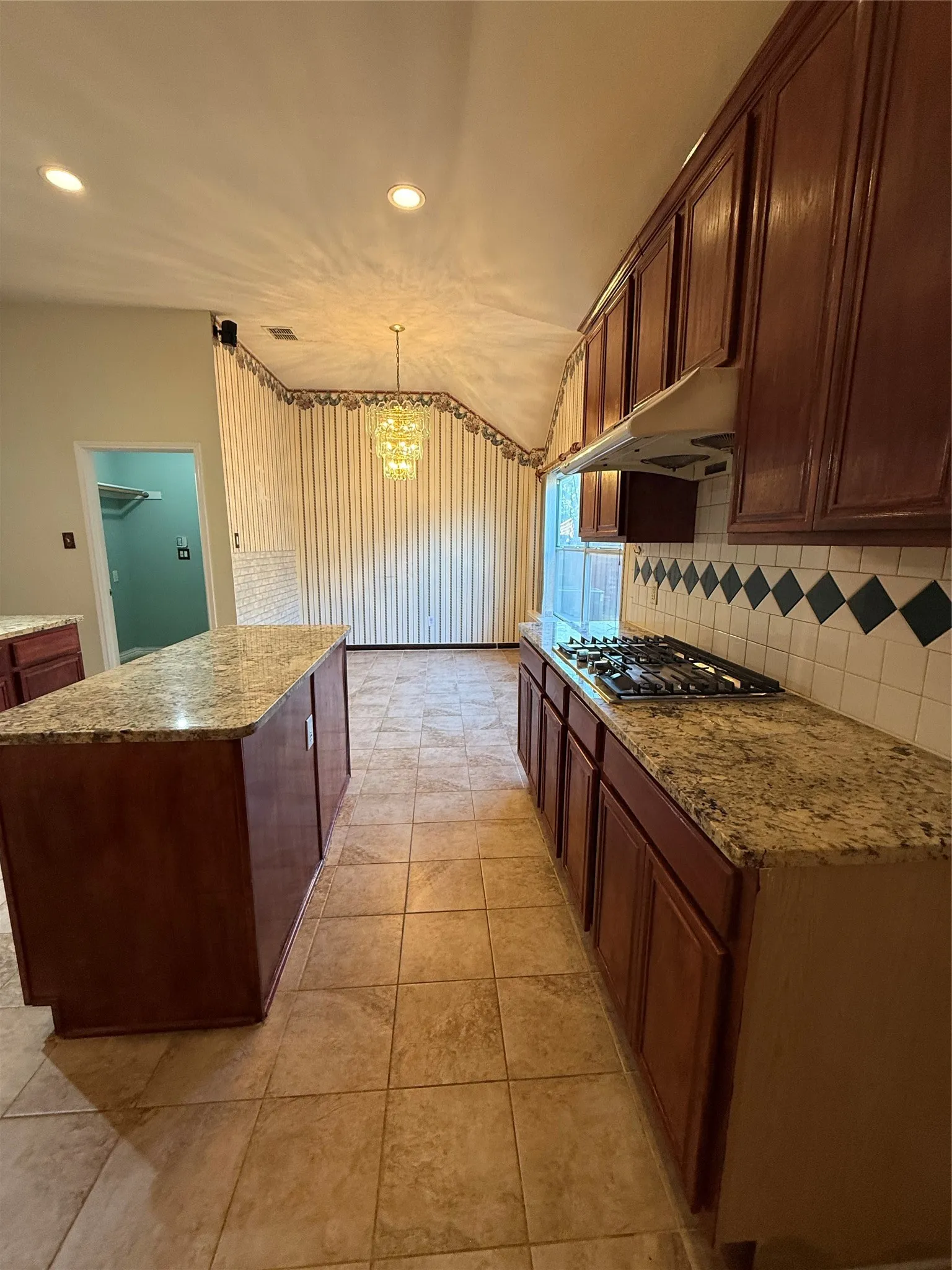 Kitchen featuring an island, recessed lighting, tile flooring, and a gas cooktop