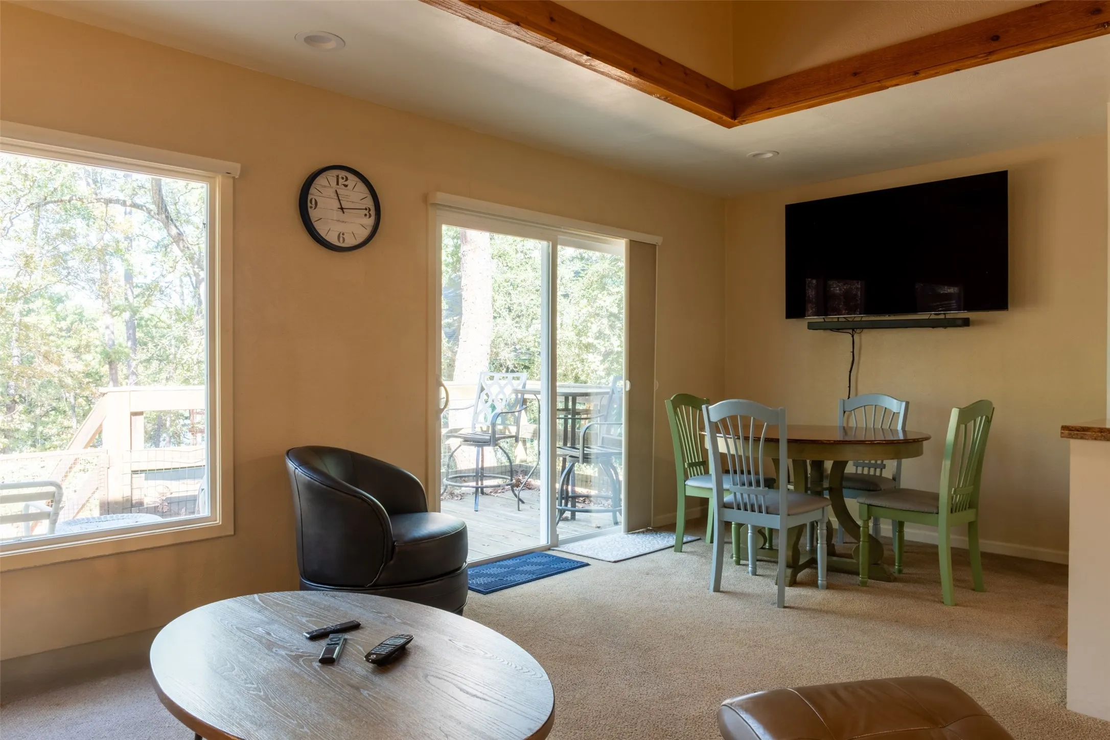 Recessed lighting, wood-finish ceiling beams, and a mounted flat-screen display