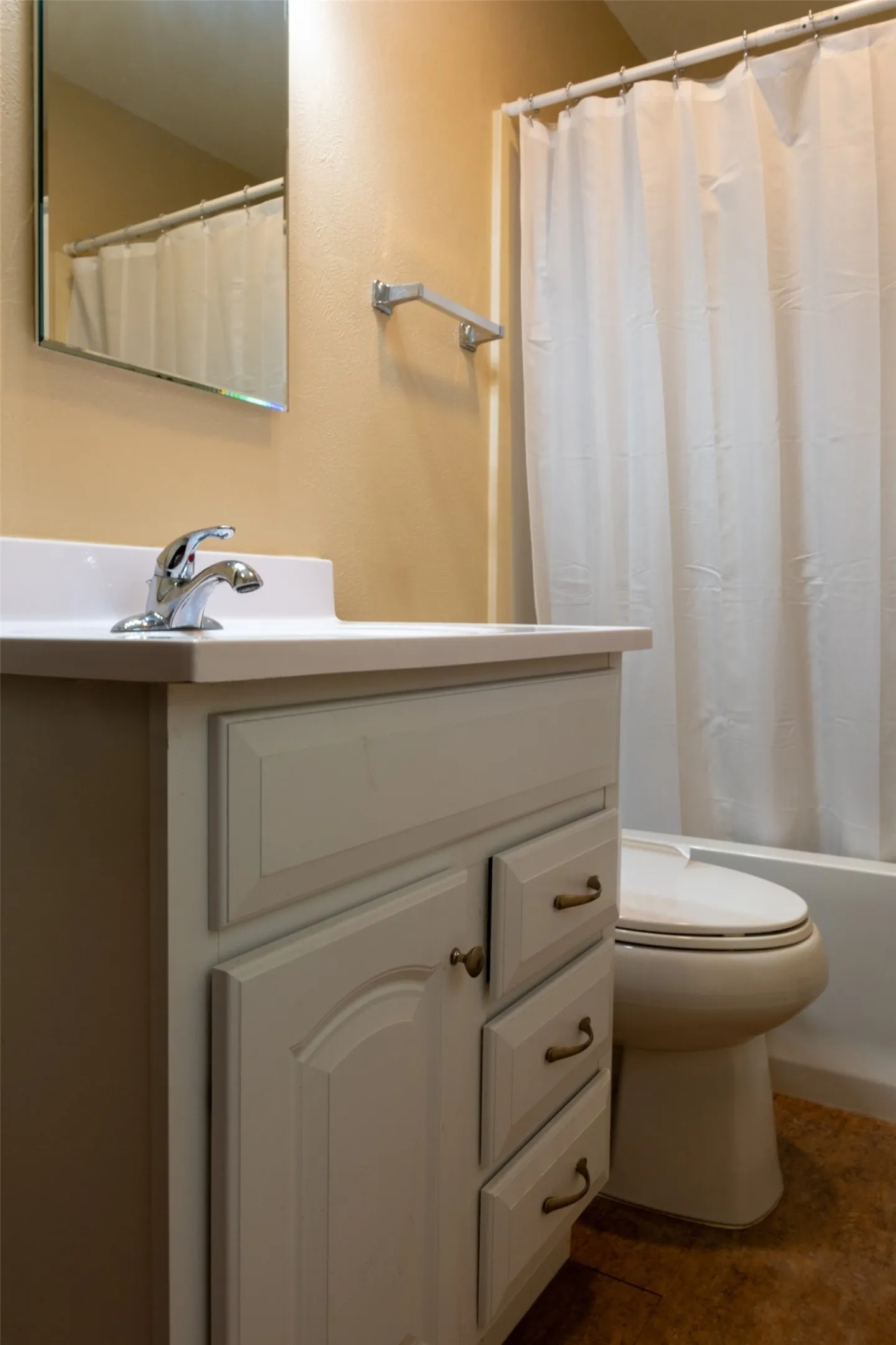 Vanity with paneled cabinetry, polished chrome faucet, and white countertop