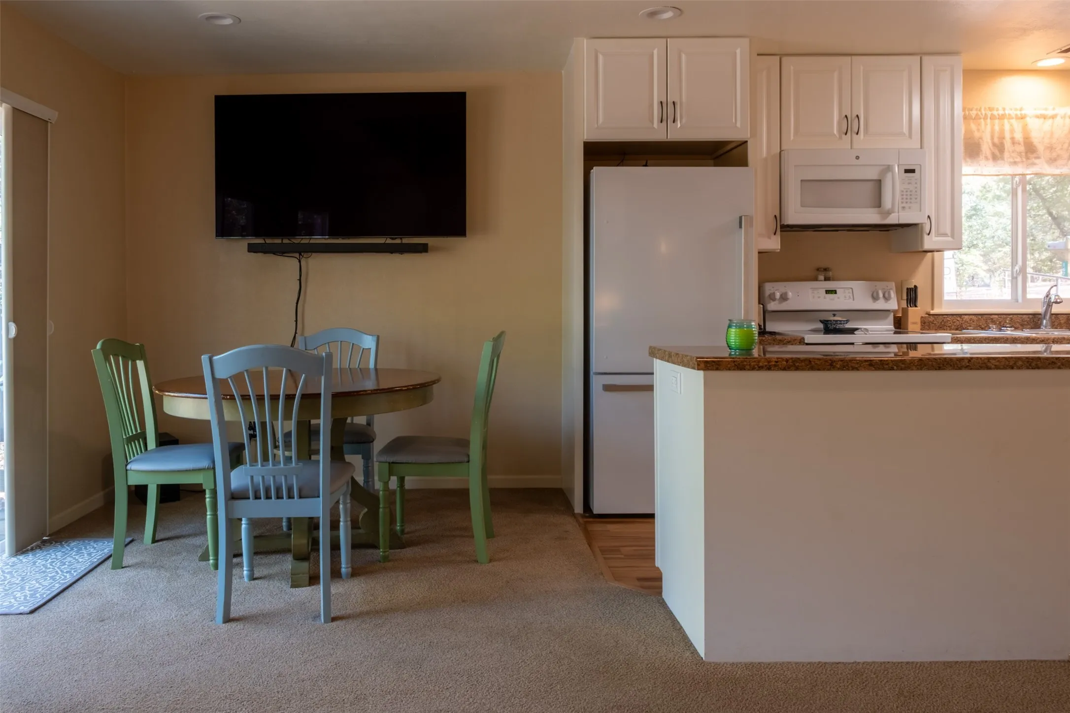 Kitchen featuring white cabinetry, built-in microwave, and a breakfast bar with a stone-finish countertop