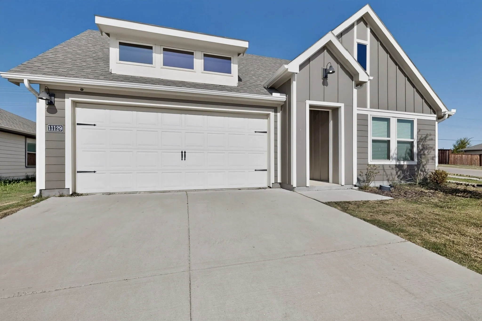 Exterior featuring board and batten siding, a single-car garage, and a concrete driveway