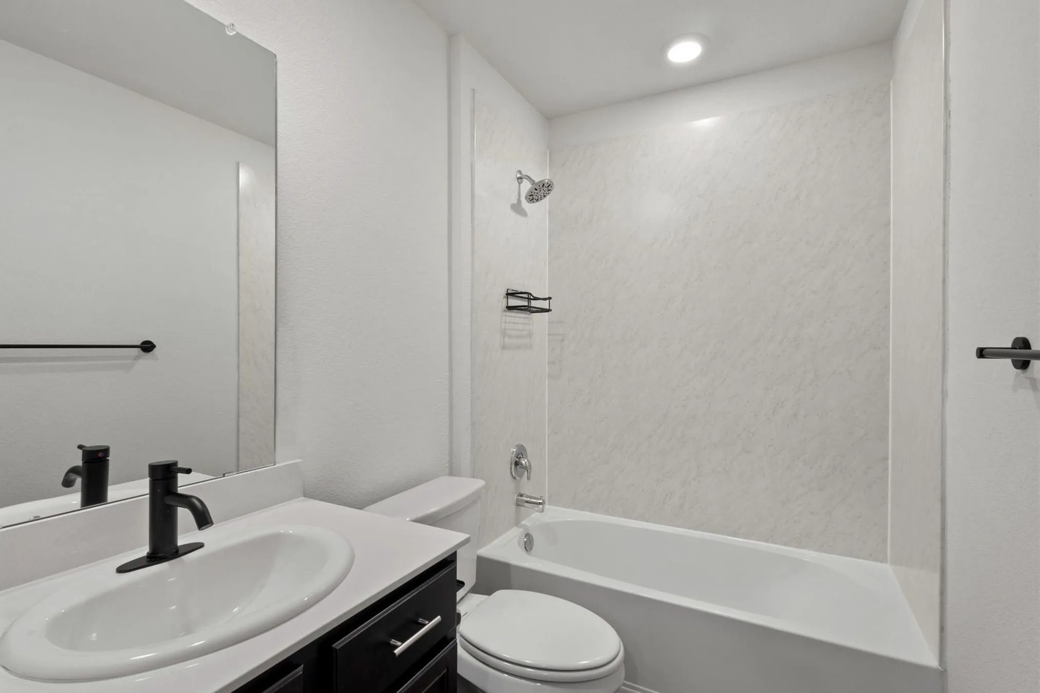 Single vanity with an oval sink, matte black faucet, and white countertop