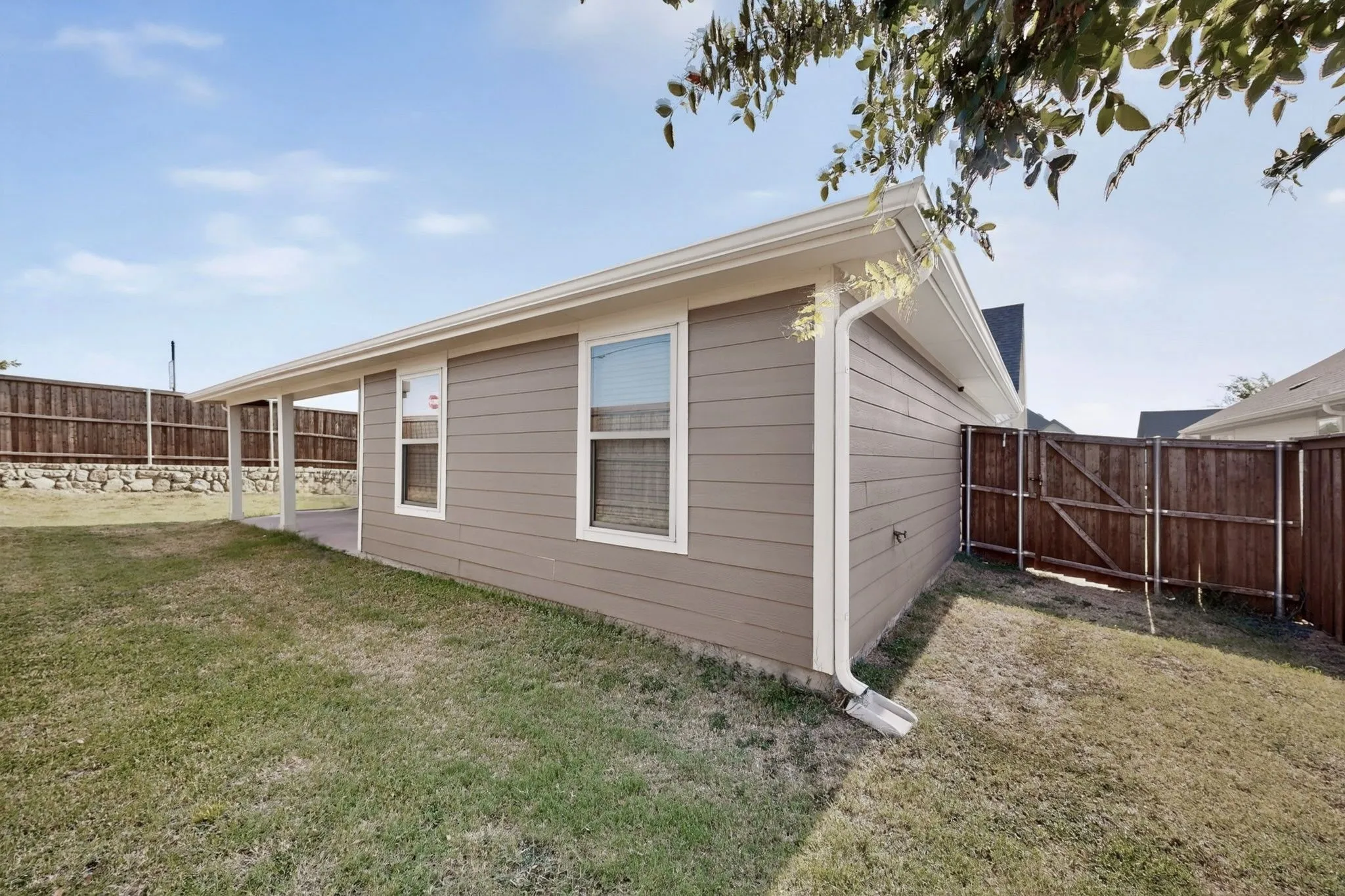 Exterior siding, covered patio, privacy fencing, side yard, and clear-story windows