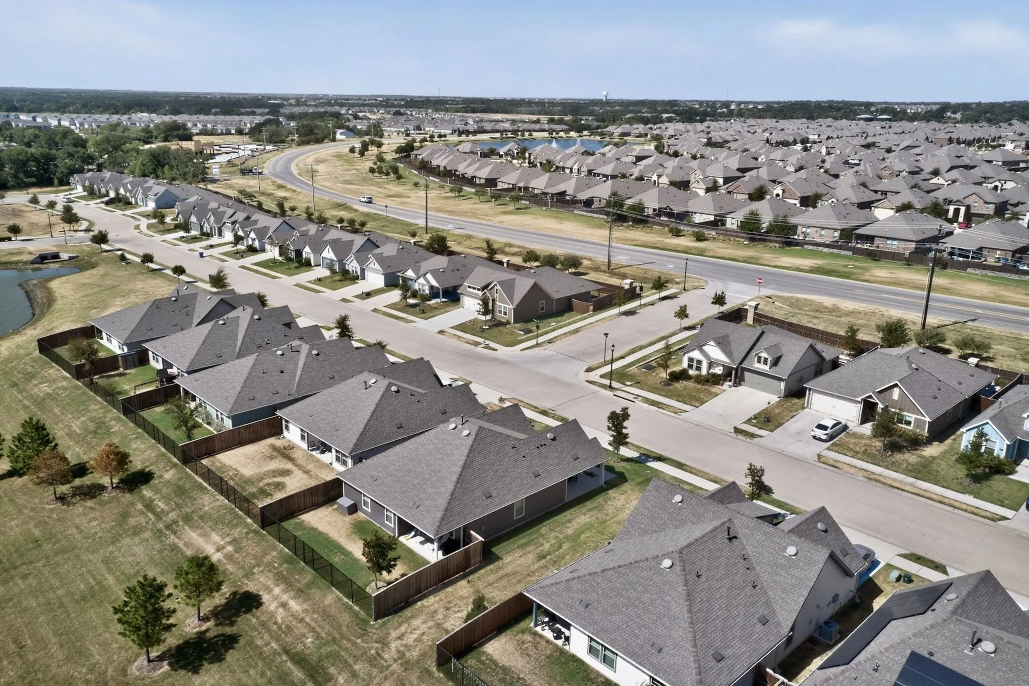 Expansive neighborhood featuring residential properties with shingle roofs and fenced backyards