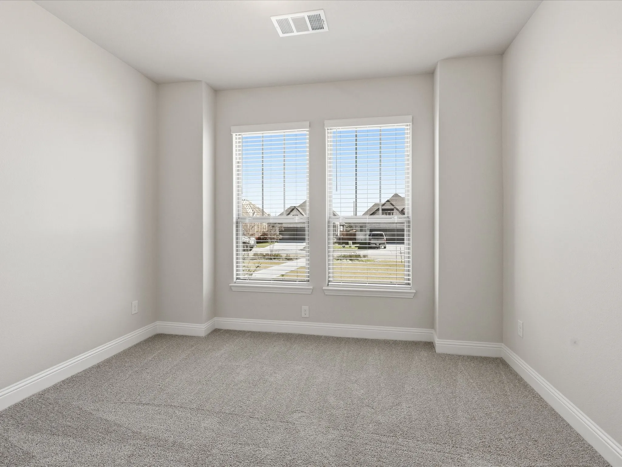 Spare room featuring light colored carpet and baseboards