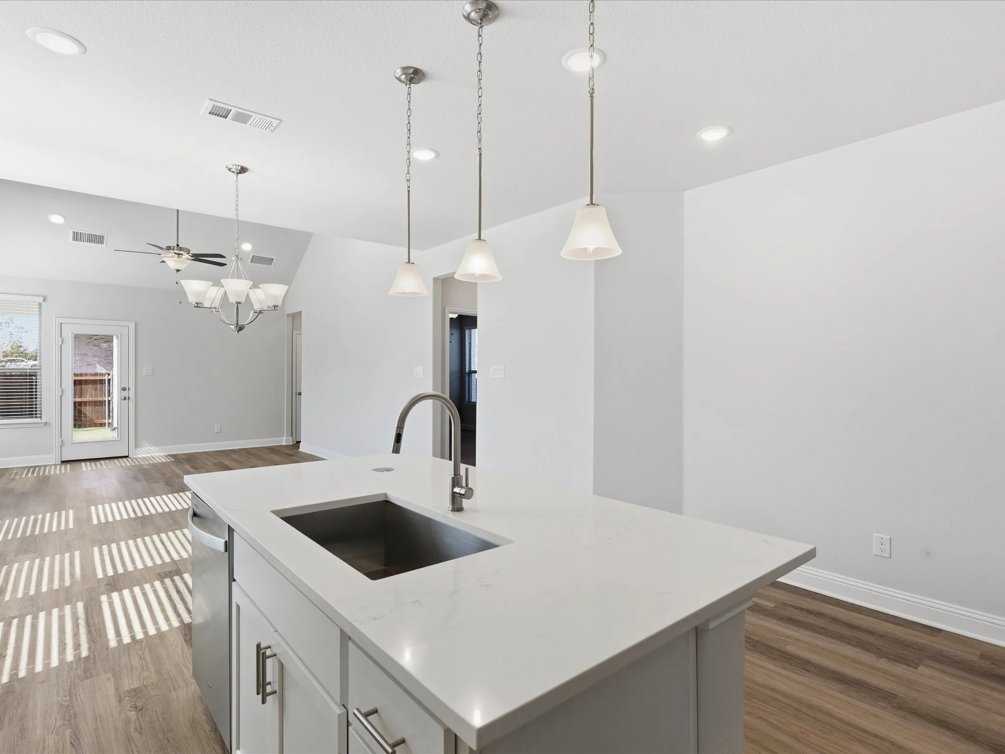 Kitchen with white cabinetry, hanging light fixtures, dark wood-style floors, an island with sink, and recessed lighting