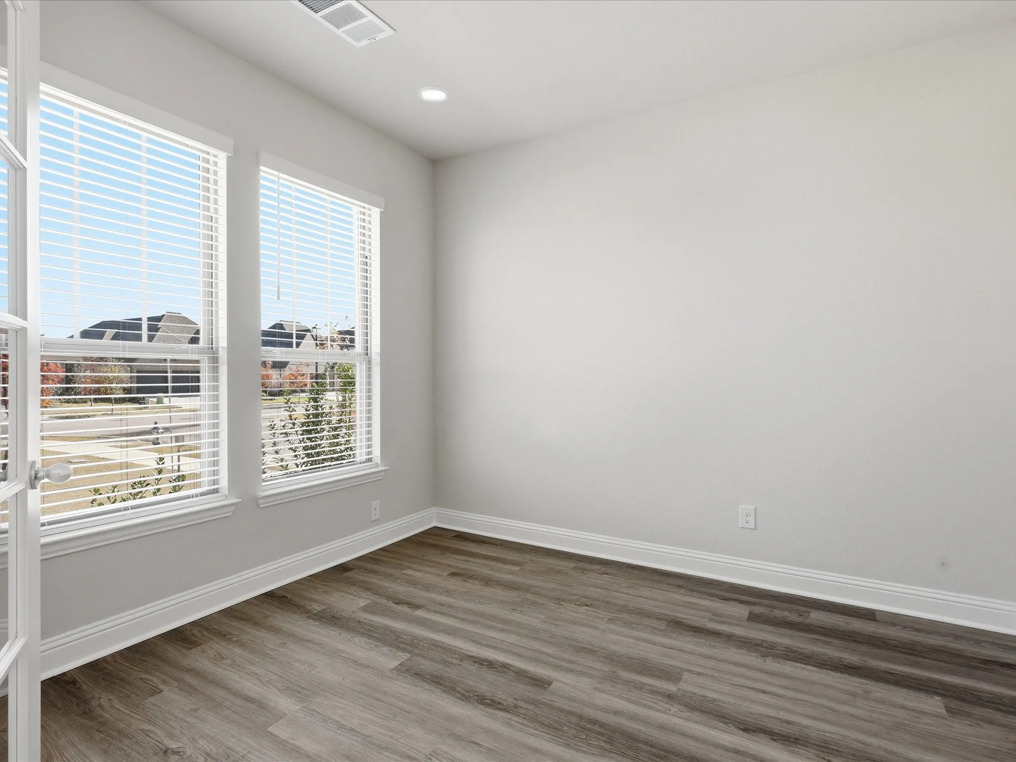 Spare room with wood finished floors and recessed lighting