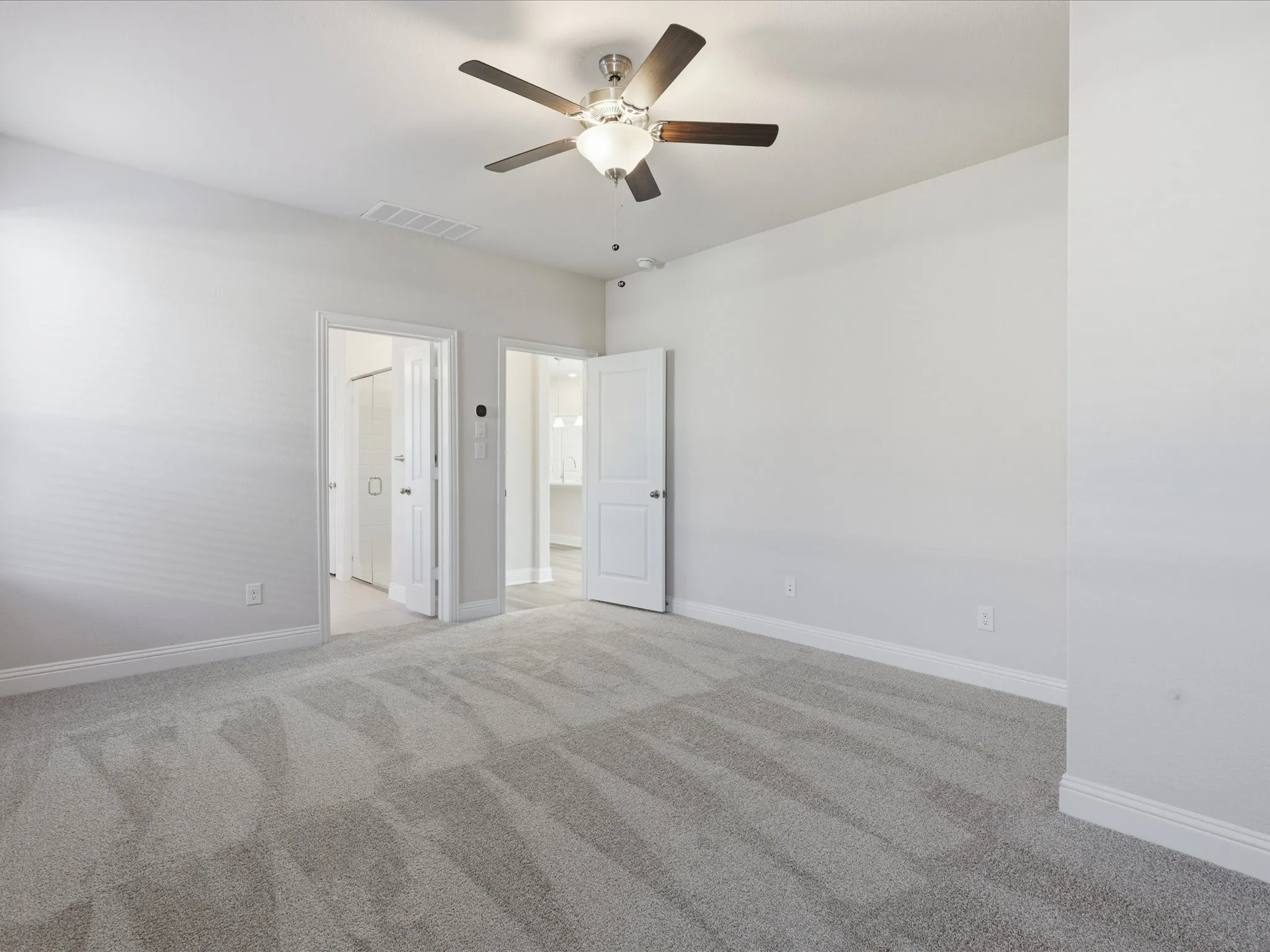 Unfurnished bedroom featuring light colored carpet and ceiling fan