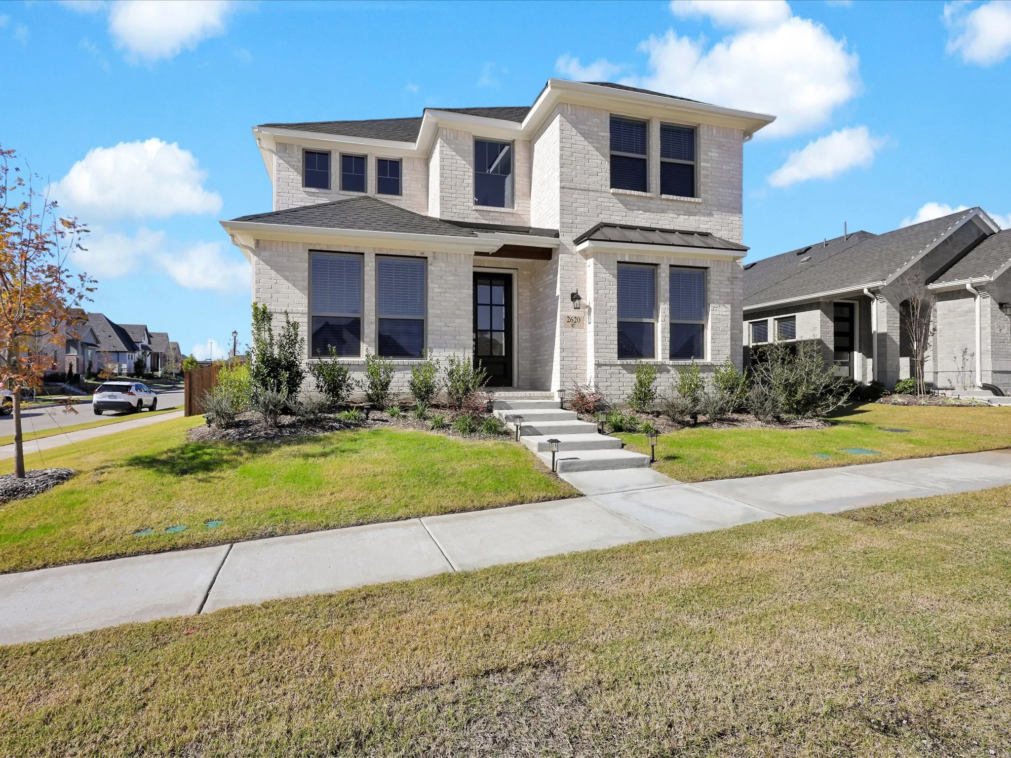 View of front of property featuring brick siding and a front lawn