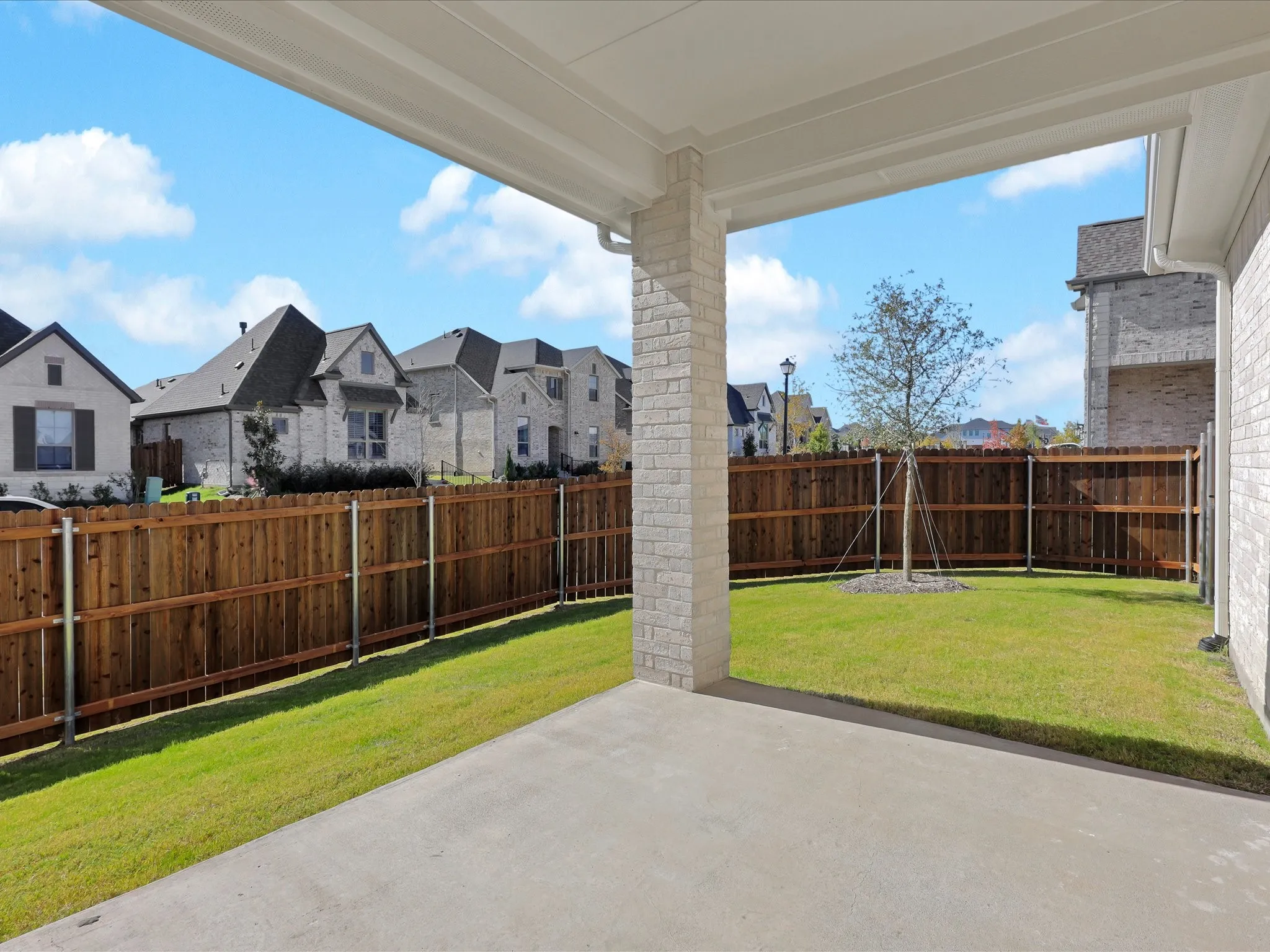 Fenced backyard with a patio area and a residential view