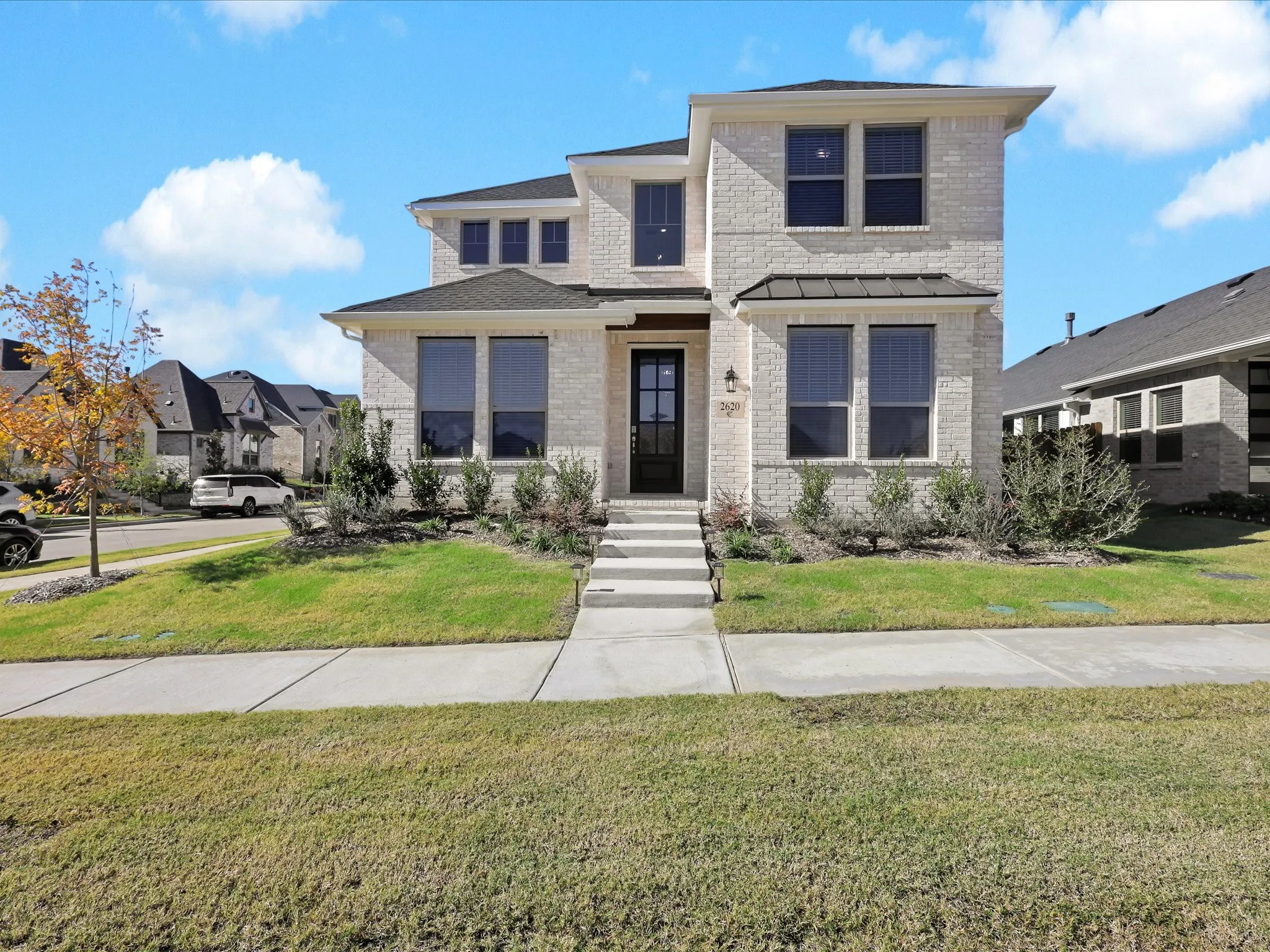 View of front of property with brick siding and a front lawn