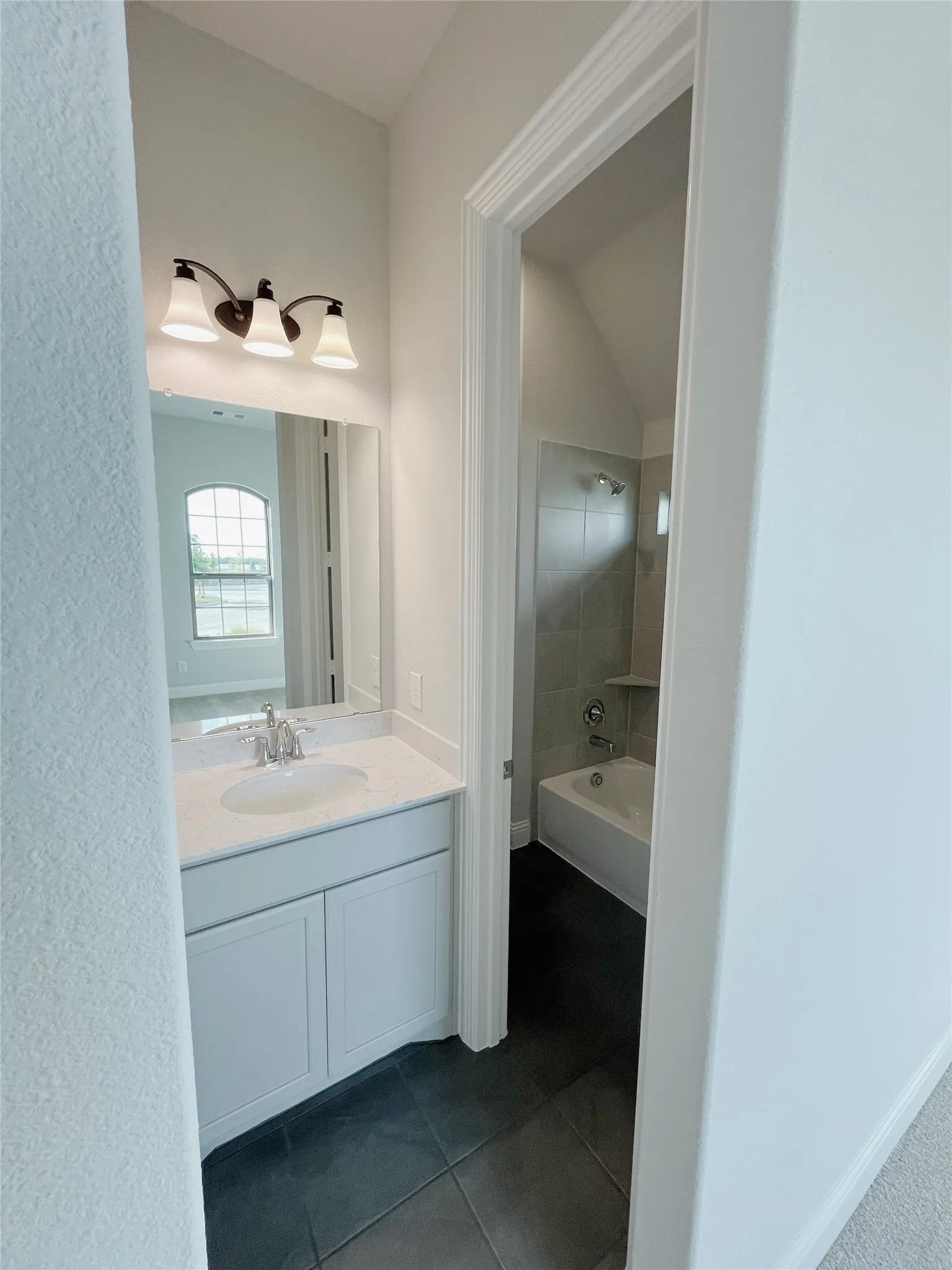 White vanity with a single basin sink, white countertop, and framed mirror