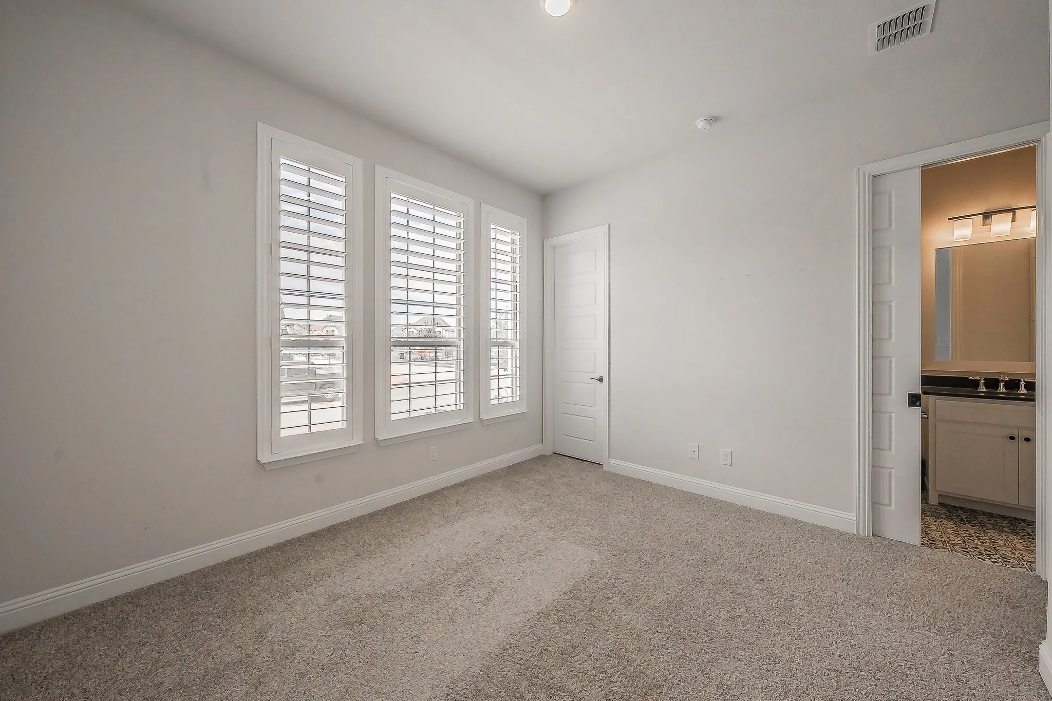 1st floor secondary bedroom.  Neutral tone walls with soft carpet flooring