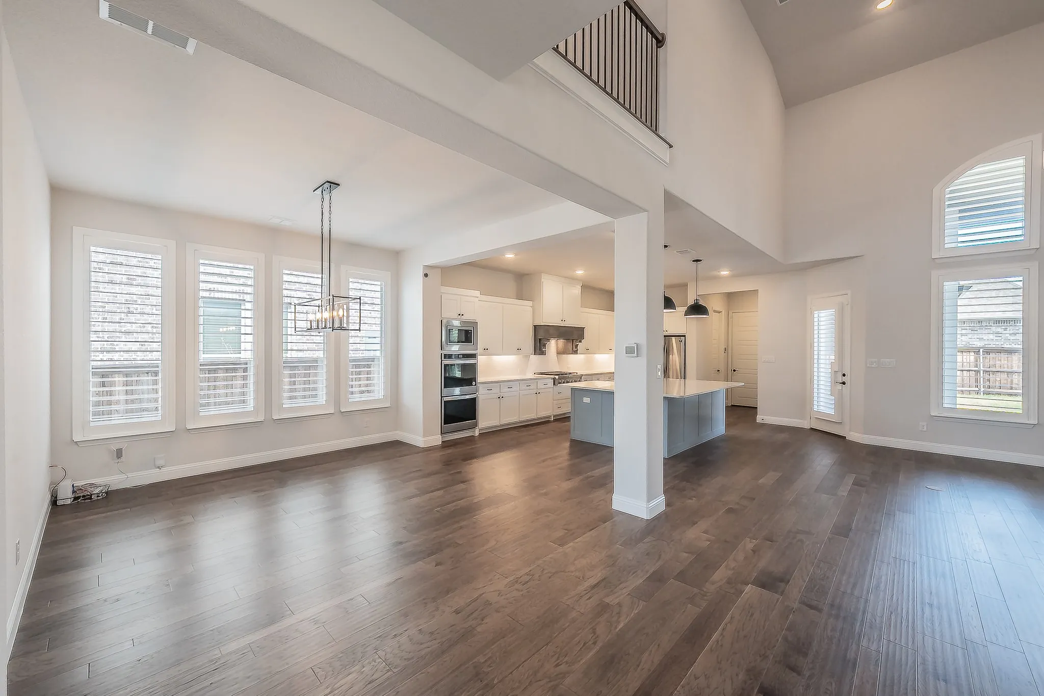 Open-concept living space featuring wood-finish flooring and high ceilings