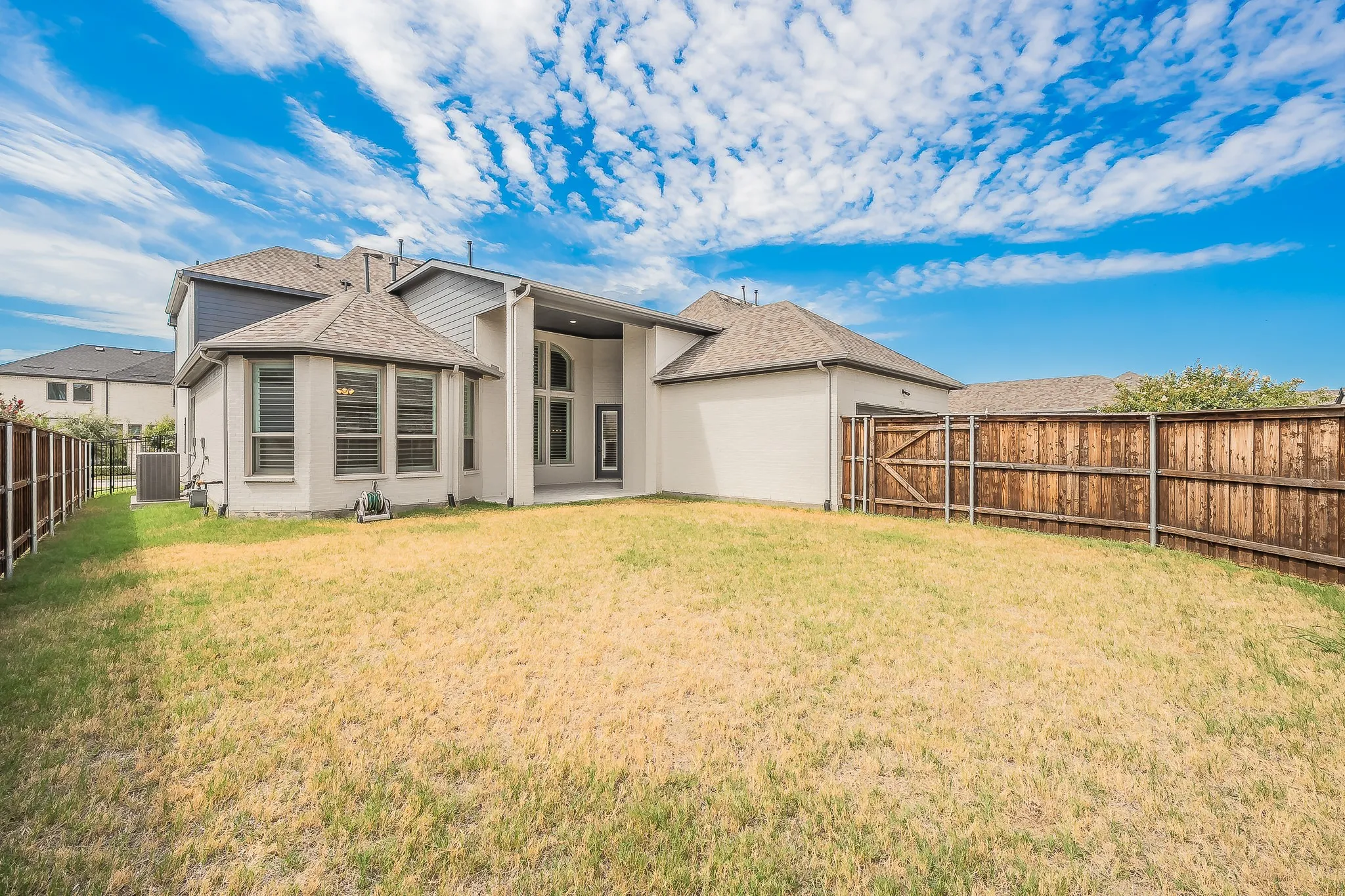 Expansive backyard featuring a wood fence and a rear patio