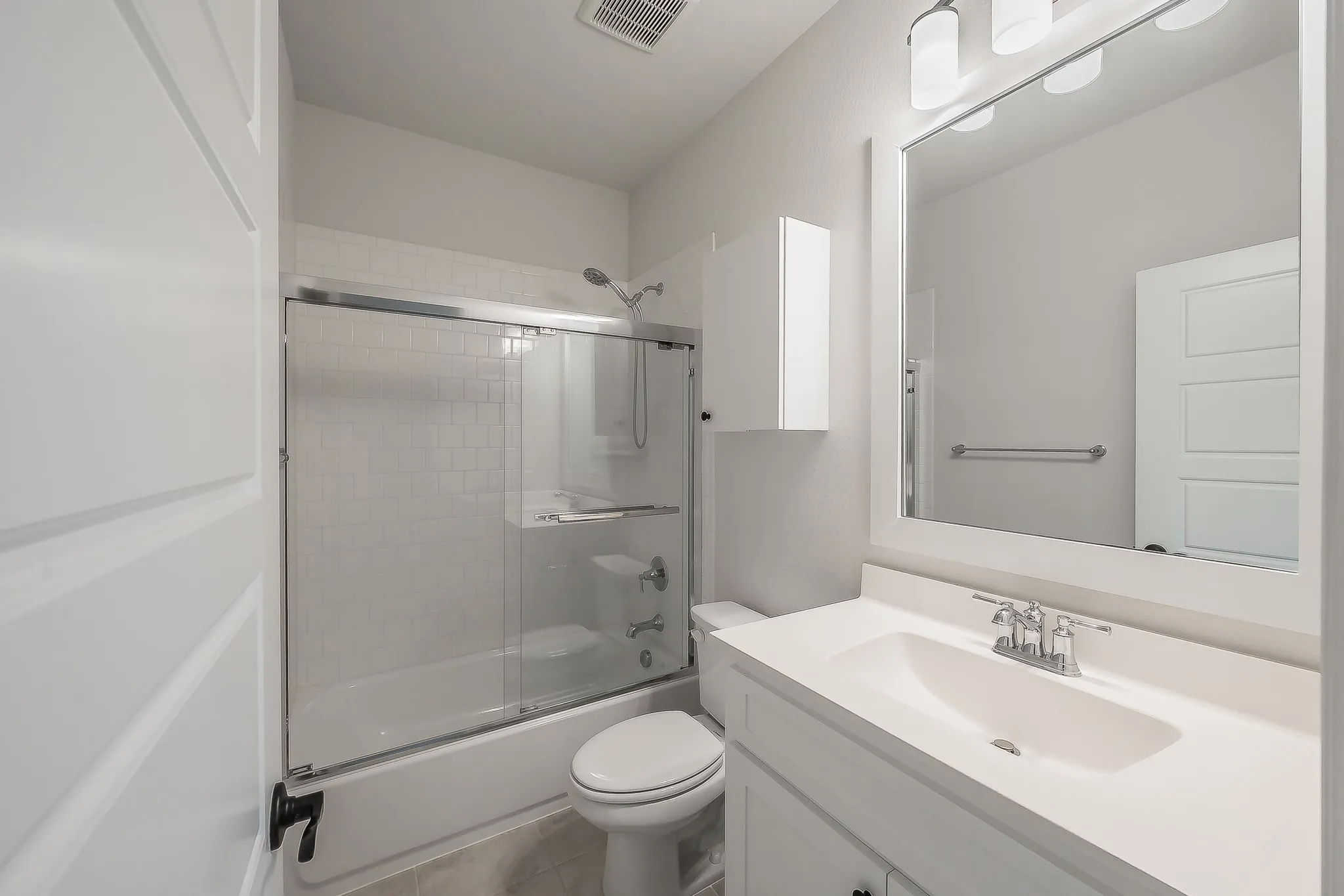 White bathroom vanity with an integrated sink, polished chrome faucet, and a large wall-mounted mirror