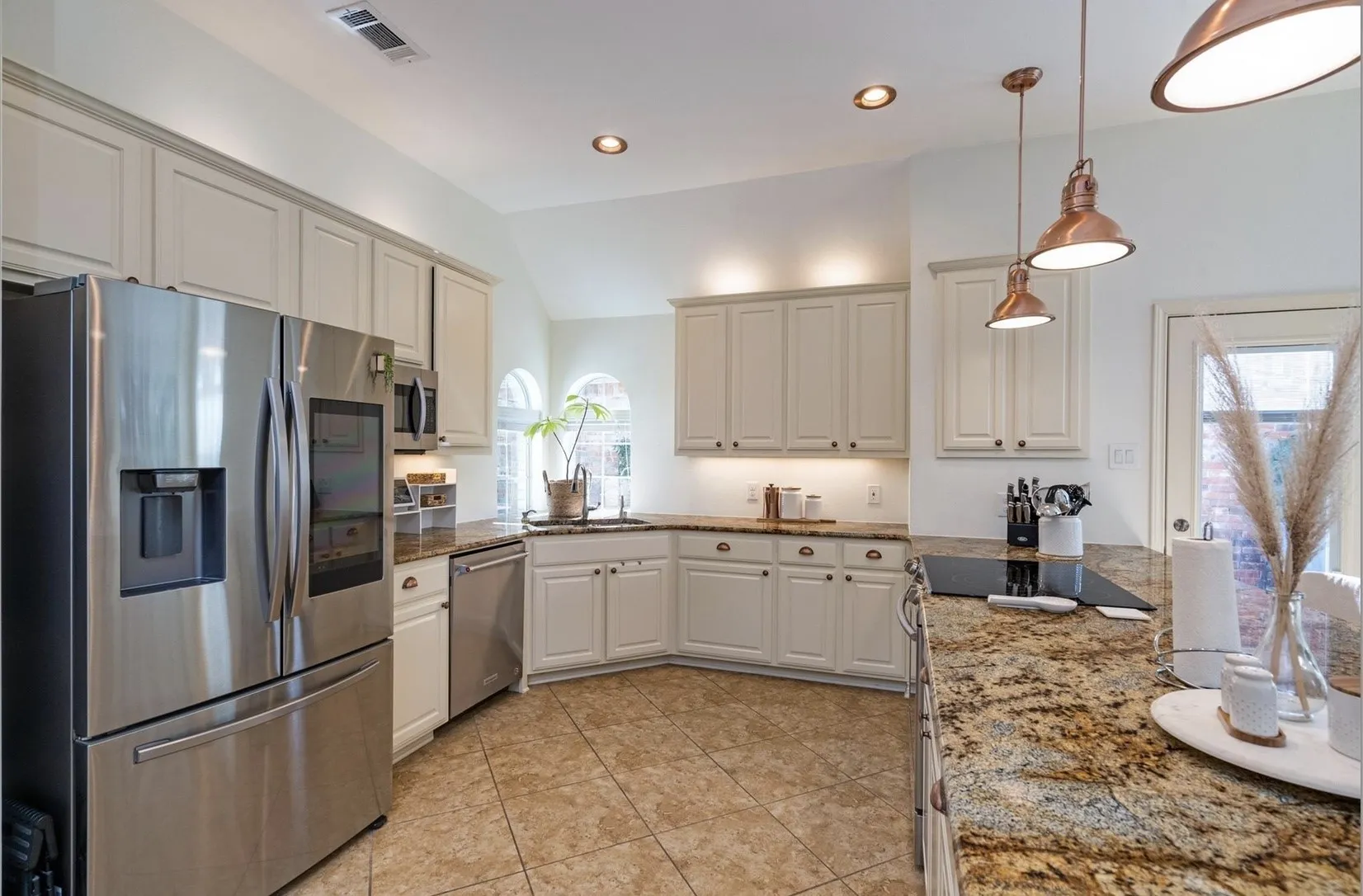 Kitchen featuring granite countertops, tile flooring, white cabinetry, stainless steel appliances, and recessed lighting