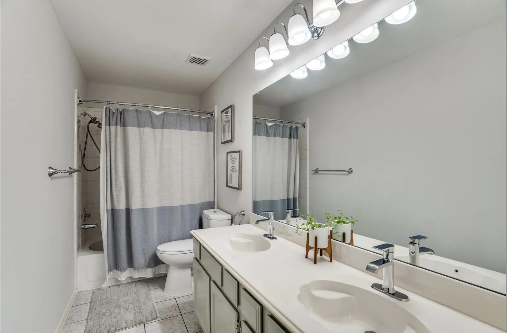 Dual vanity with integrated sinks, chrome fixtures, and an expansive mirror
