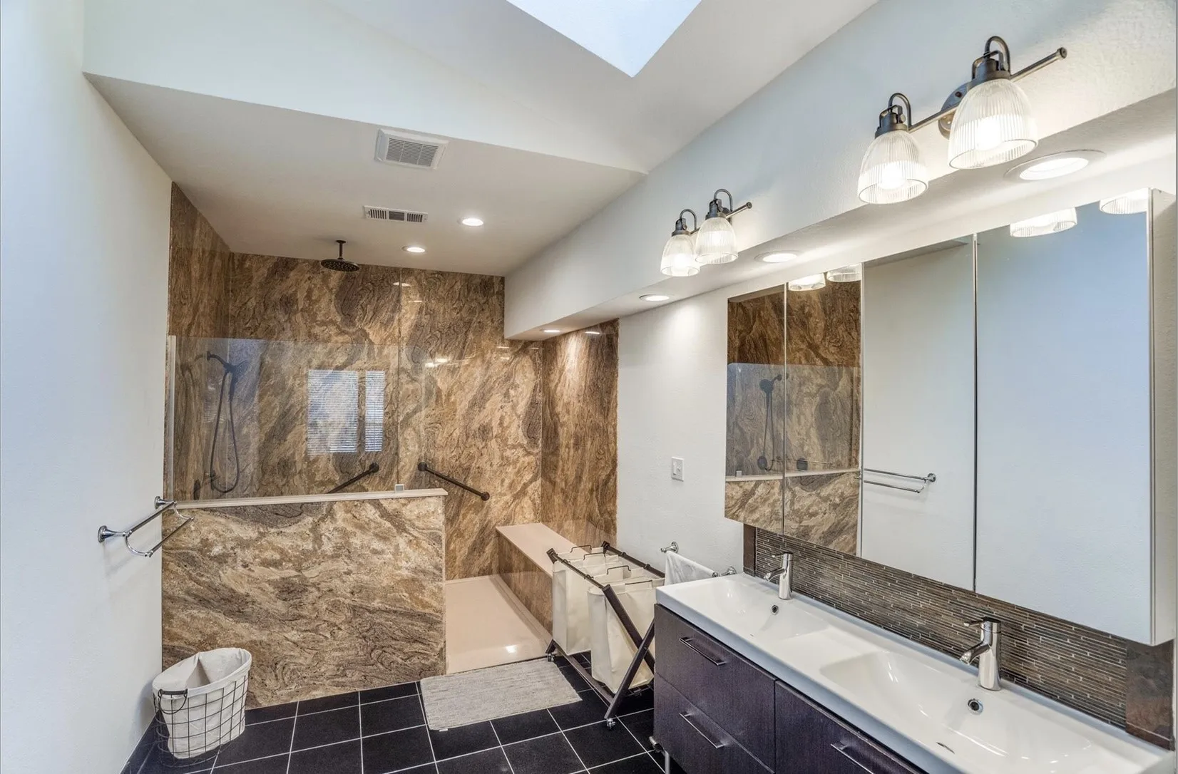 Walk-in shower with natural stone-look tile, glass enclosure, and built-in bench