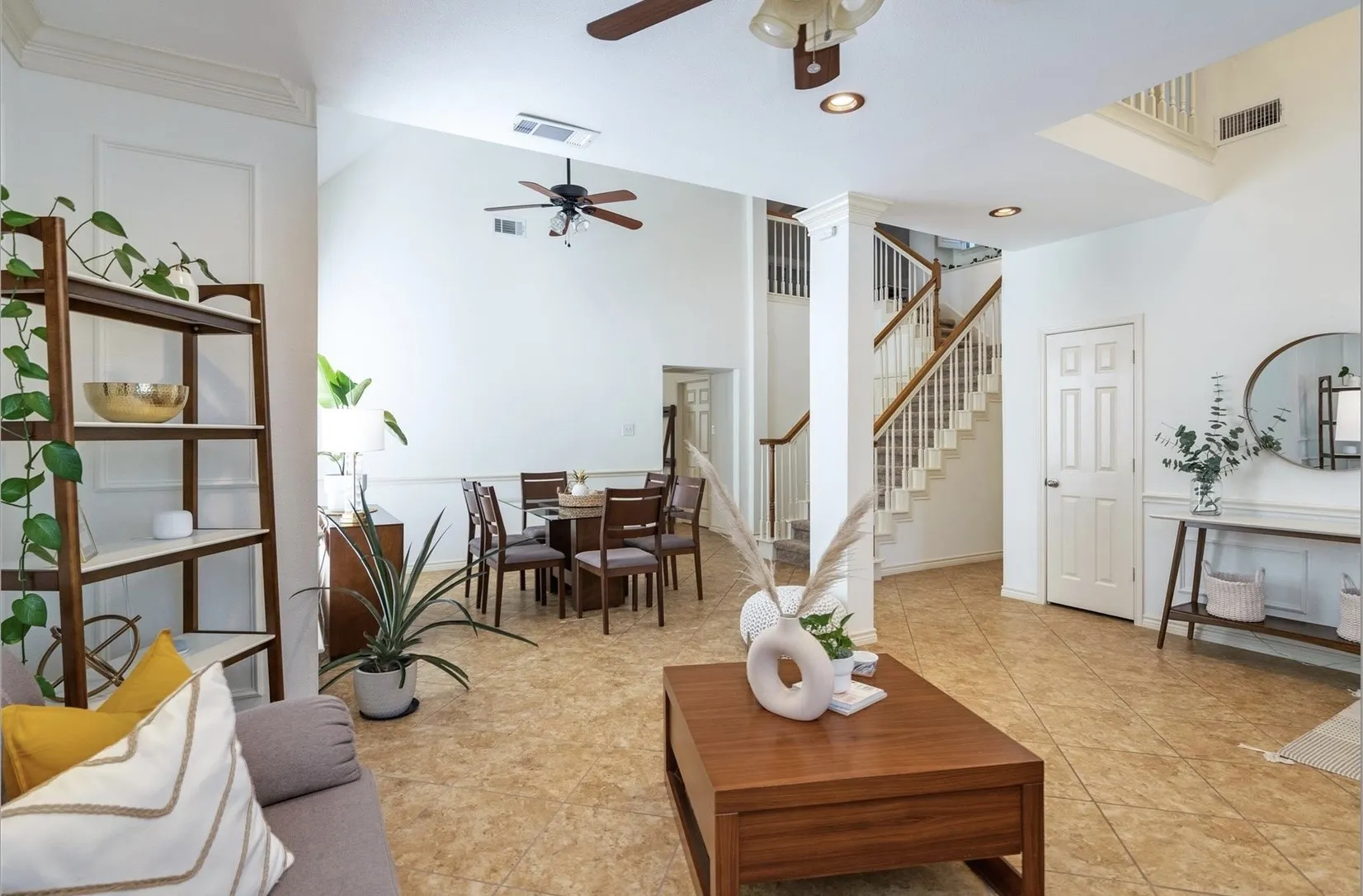 Vaulted ceilings, tile flooring, and a multi-level staircase with wood railings