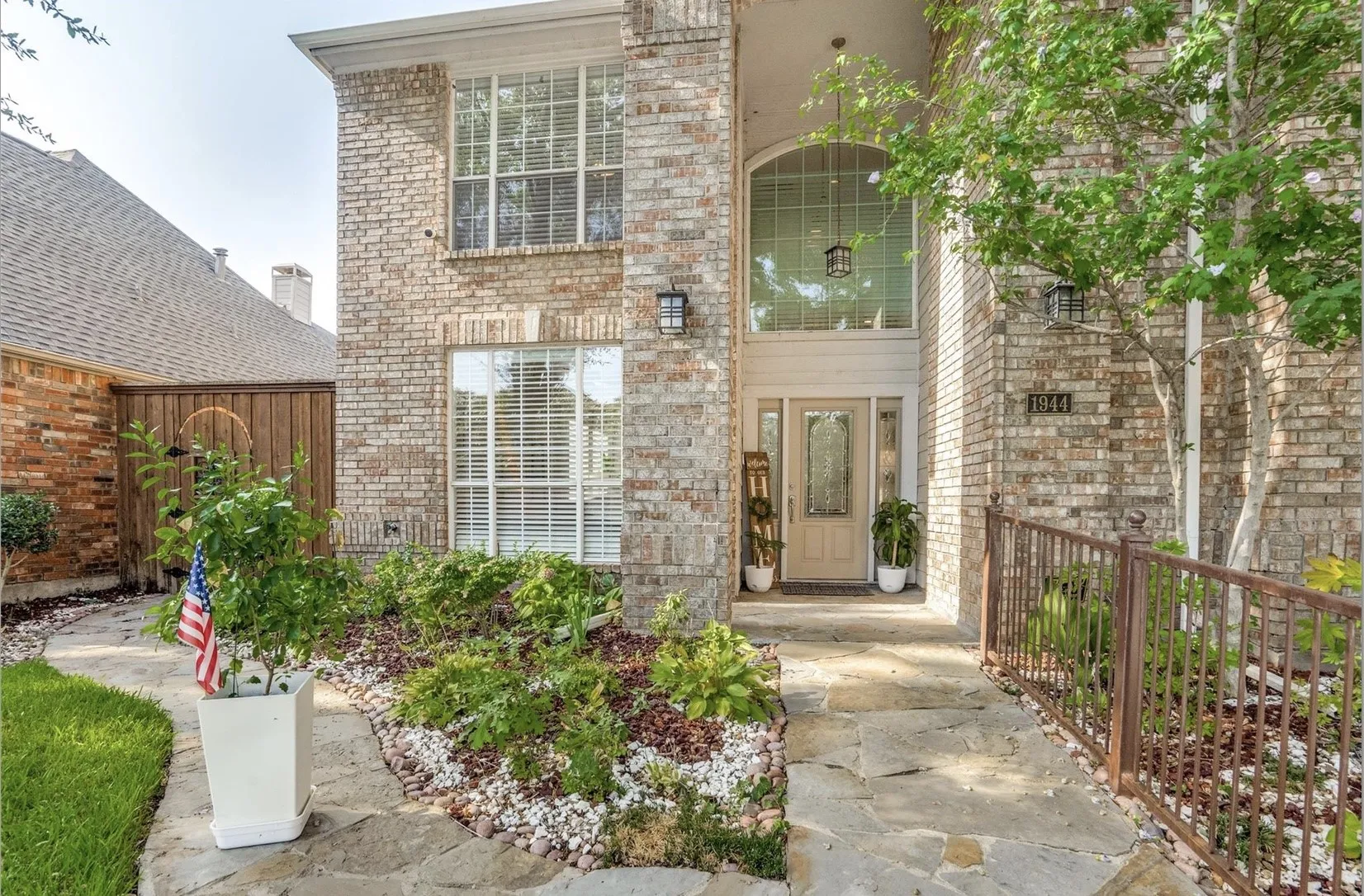 Brick exterior with multiple windows, arched entryway, and a stone walkway