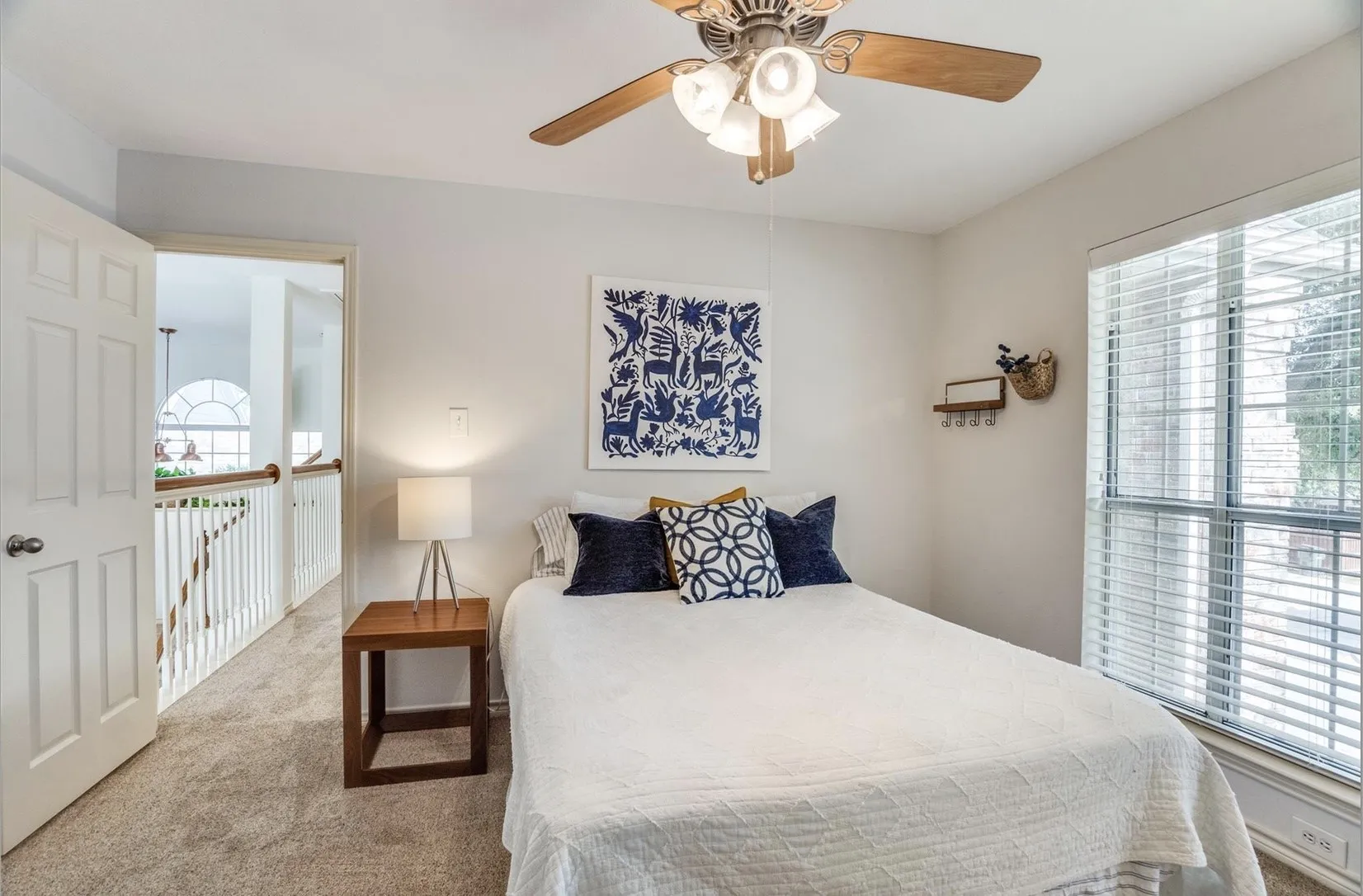 Bedroom featuring a ceiling fan with light fixture, neutral carpeting, and a window with blinds